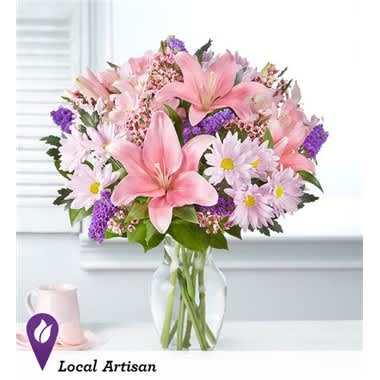 Pink lilies and daisies in a clear glass vase