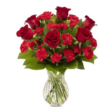 Red roses and carnations in a clear glass vase