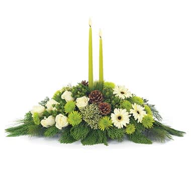 Winter Solstice Centerpiece - There may be a chill in the air, but there's the warmth of floral beauty in the home with this delightful centerpiece featuring trachelium, roses, button poms, gerbera daisies, hypericum and green candles in a designer-inspired dish. Measures 8"H by 24"L.