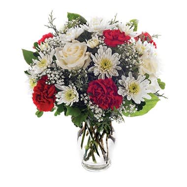 Holiday Happiness - Spread the cheer and create glowing smiles of joy. This assortment sings the season's praises with white mums, red carnations, white roses and complementing gypsophila in a splendid glass fluted vase. Measures 18"H by 15"L.