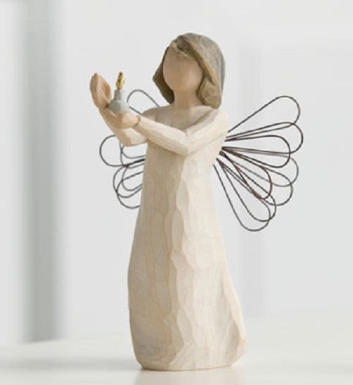 Wooden angel figurine holding a small candle