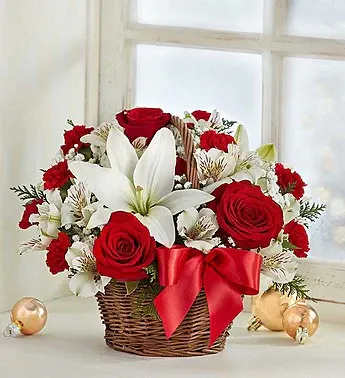 Fields of Europe Christmas Basket - Fields of Europe Basket Christmas Arrangement: Our florists have hand-arranged the freshest red roses, white lilies and greens inside a charming handled basket. Filled with the classic colors of Christmas, our exclusive bouquet is inspired by the beauty of such cities as Tuscany and Provence and is an inspired way to thank the party hostess. Or use it as a centerpiece in your own holiday home, during the holidays or anytime this winter.