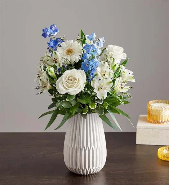 Treasured Memories - Blue and White - Hand designed by our florists, this elegant gathering features soothing blue and white blooms, along with accents of cascading greenery. It’s arranged in our keepsake White Modern Vase to capture treasured memories of a special loved one.