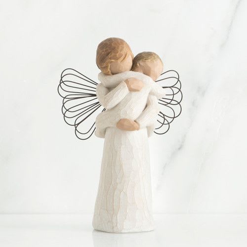 Wooden-style angel figurine holding a child with wire wings in soft neutral tones.