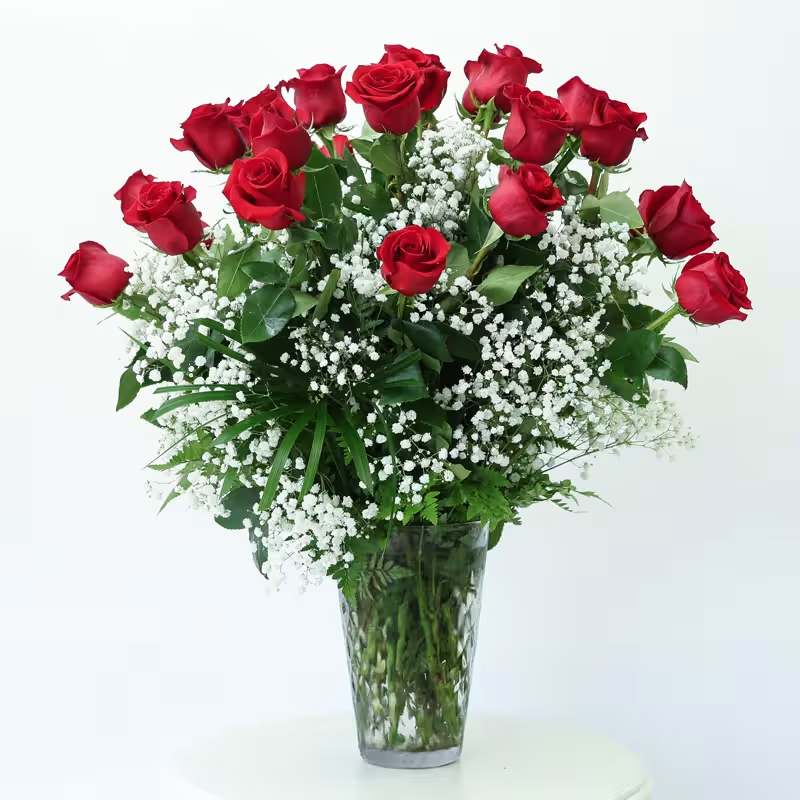 Red roses and baby's breath in a clear glass vase