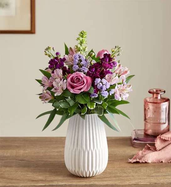 Mixed pink and purple flower arrangement with a rose and alstroemeria in a white ceramic vase