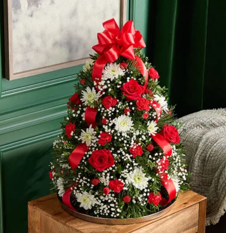 Cone-shaped floral arrangement with red roses, white daisies, and red ribbon