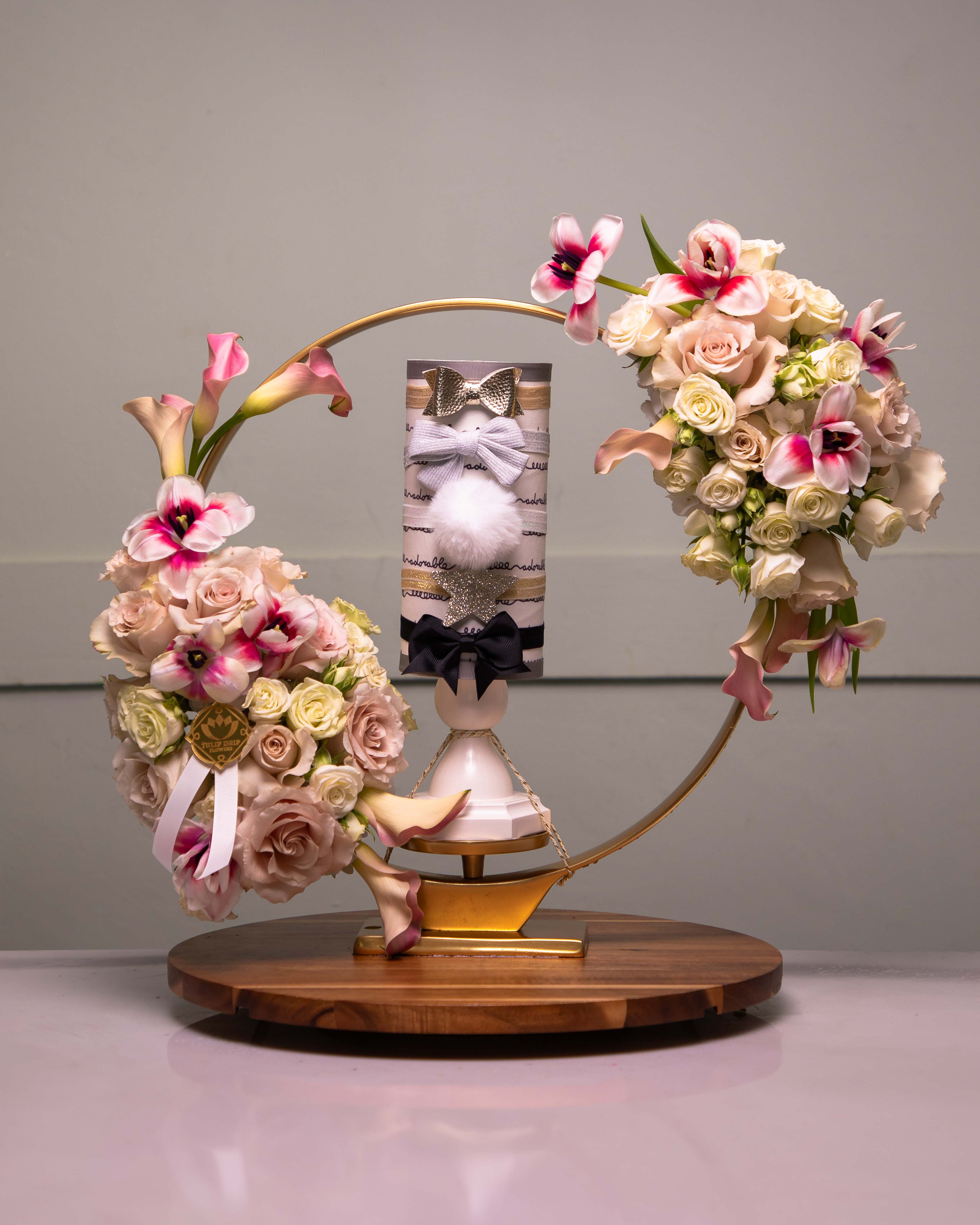 Two floral arrangements with roses and calla lilies on a decorative stand