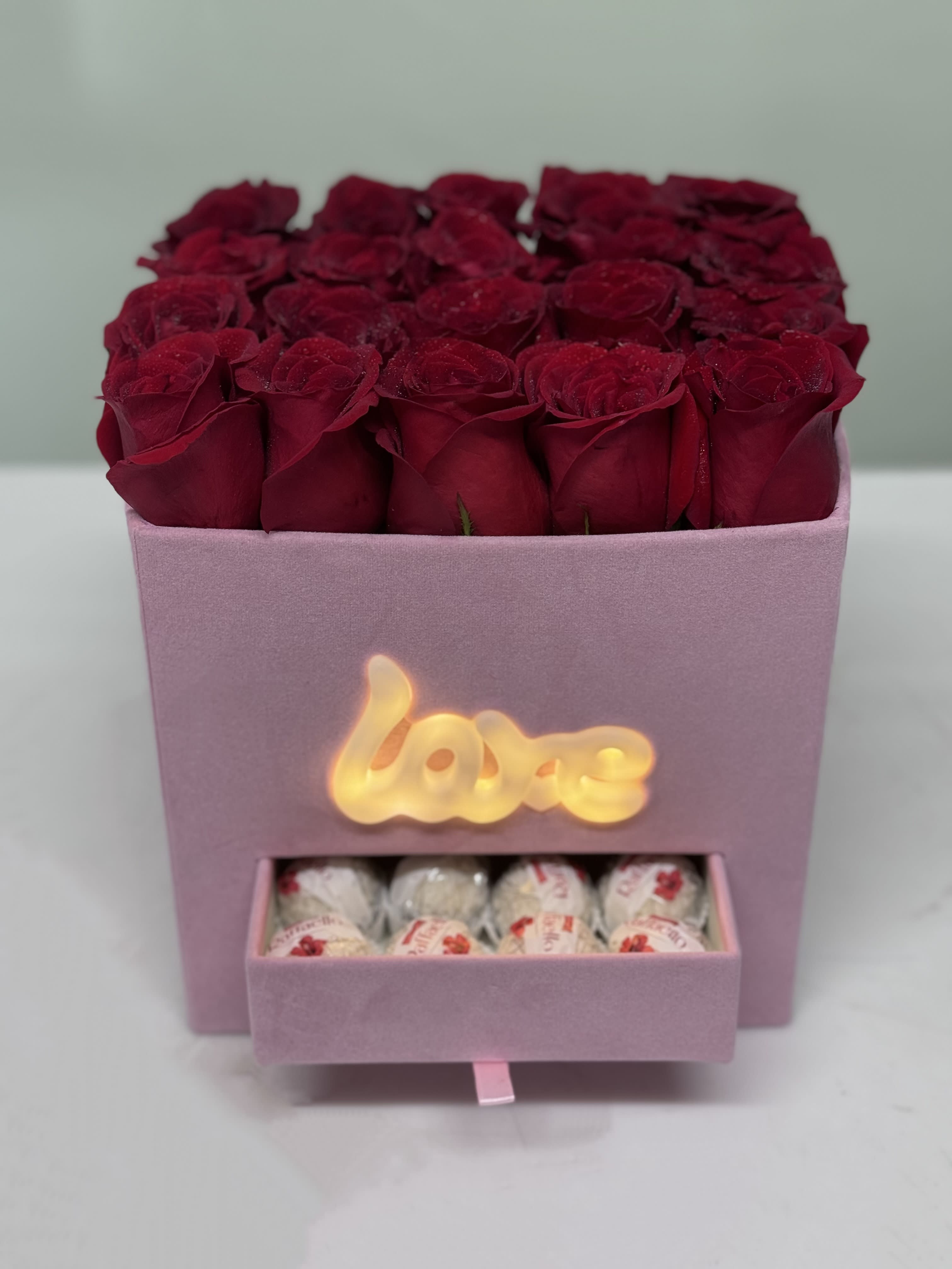 Pink box of red roses with a drawer of chocolates
