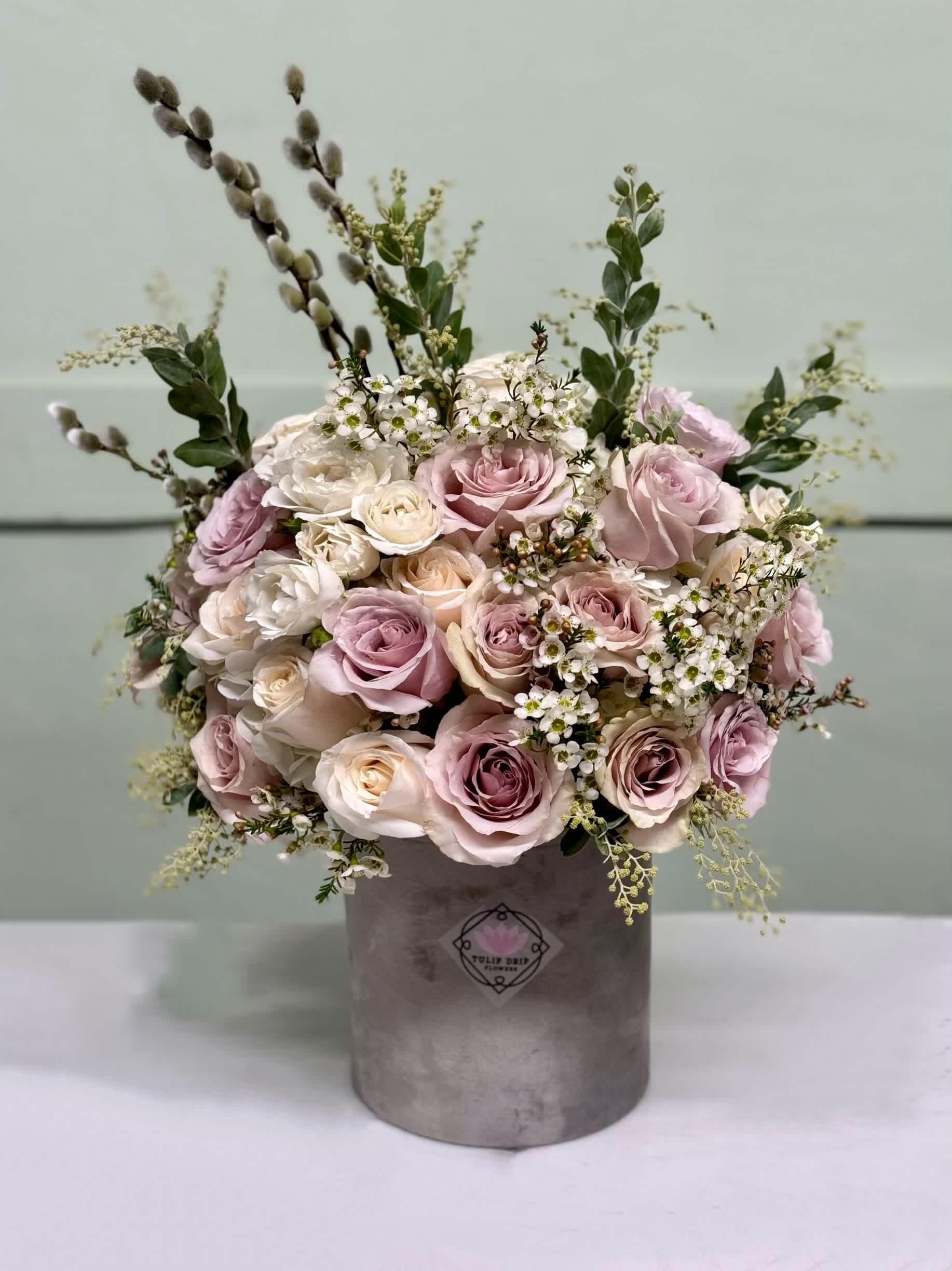 Bouquet of blush and white roses in a gray hatbox