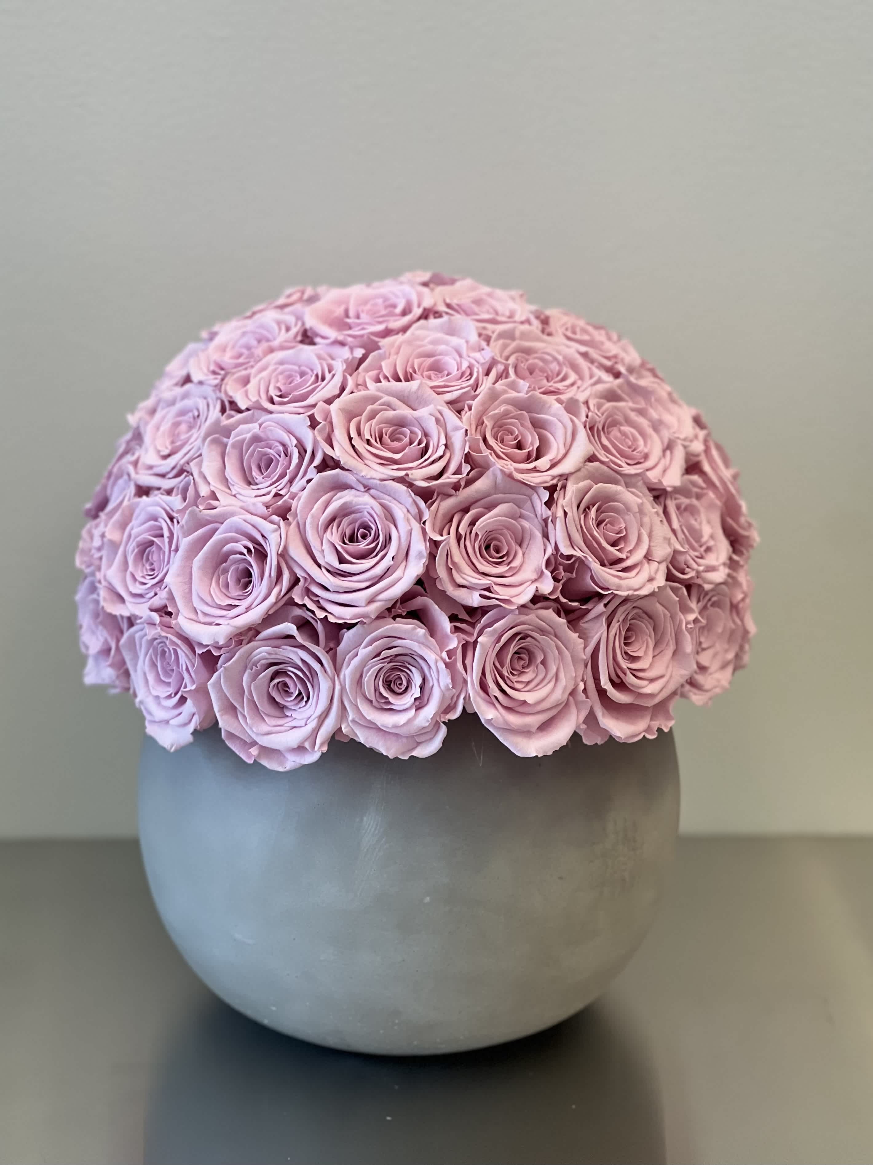 Round bouquet of pale pink roses in a gray vase