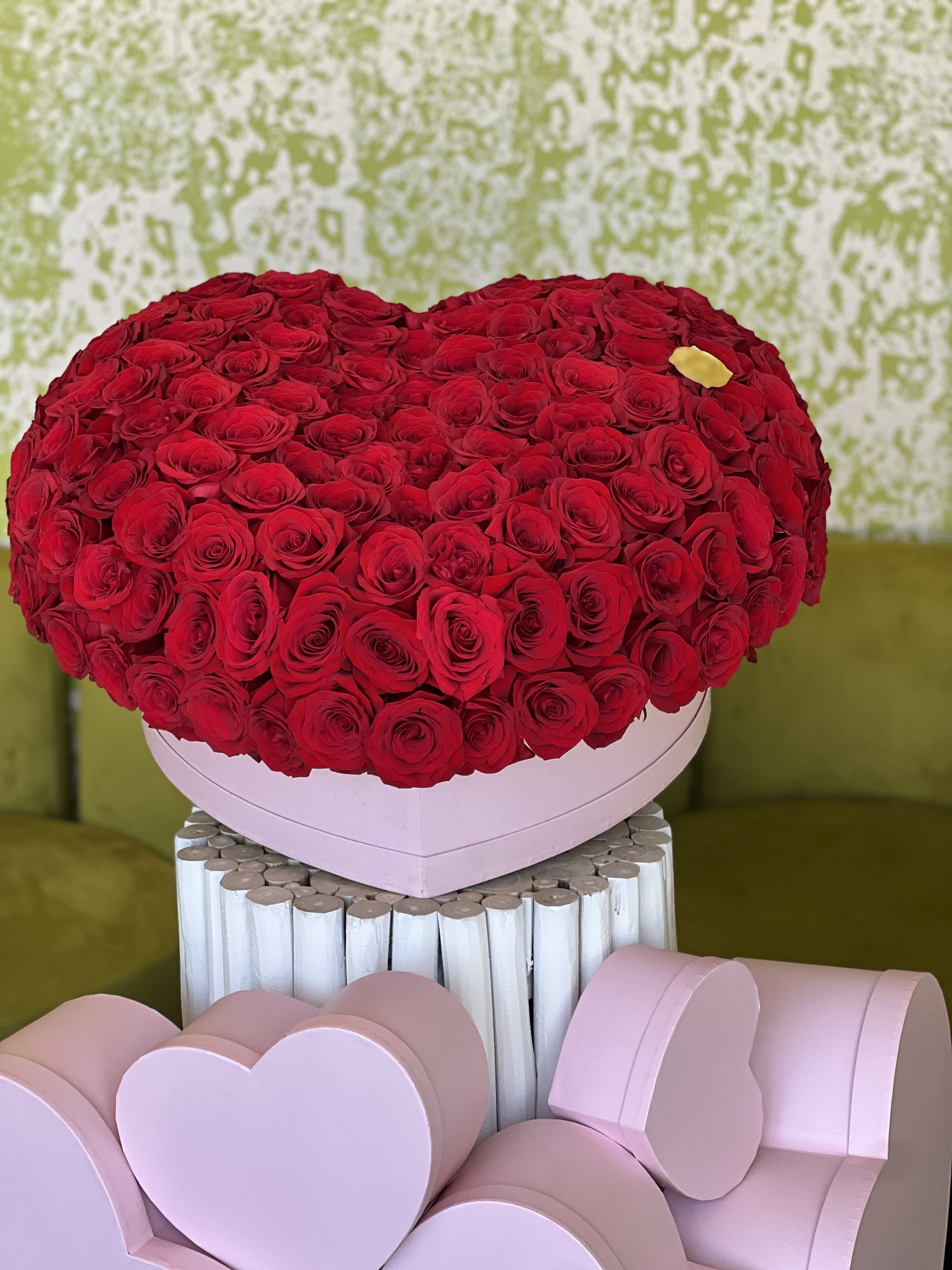 Heart-shaped box of red roses with pink heart boxes below