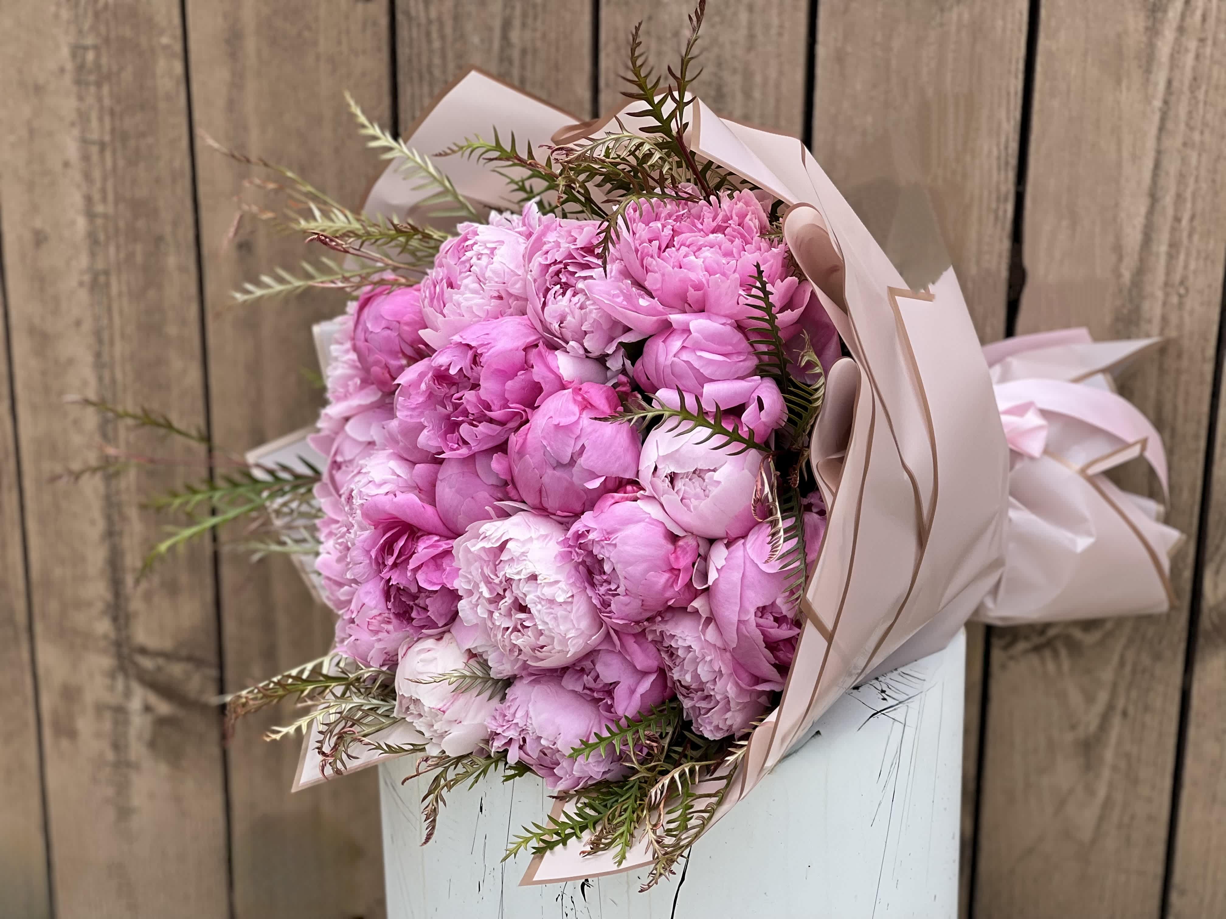 Bouquet of pink peonies wrapped in pale paper