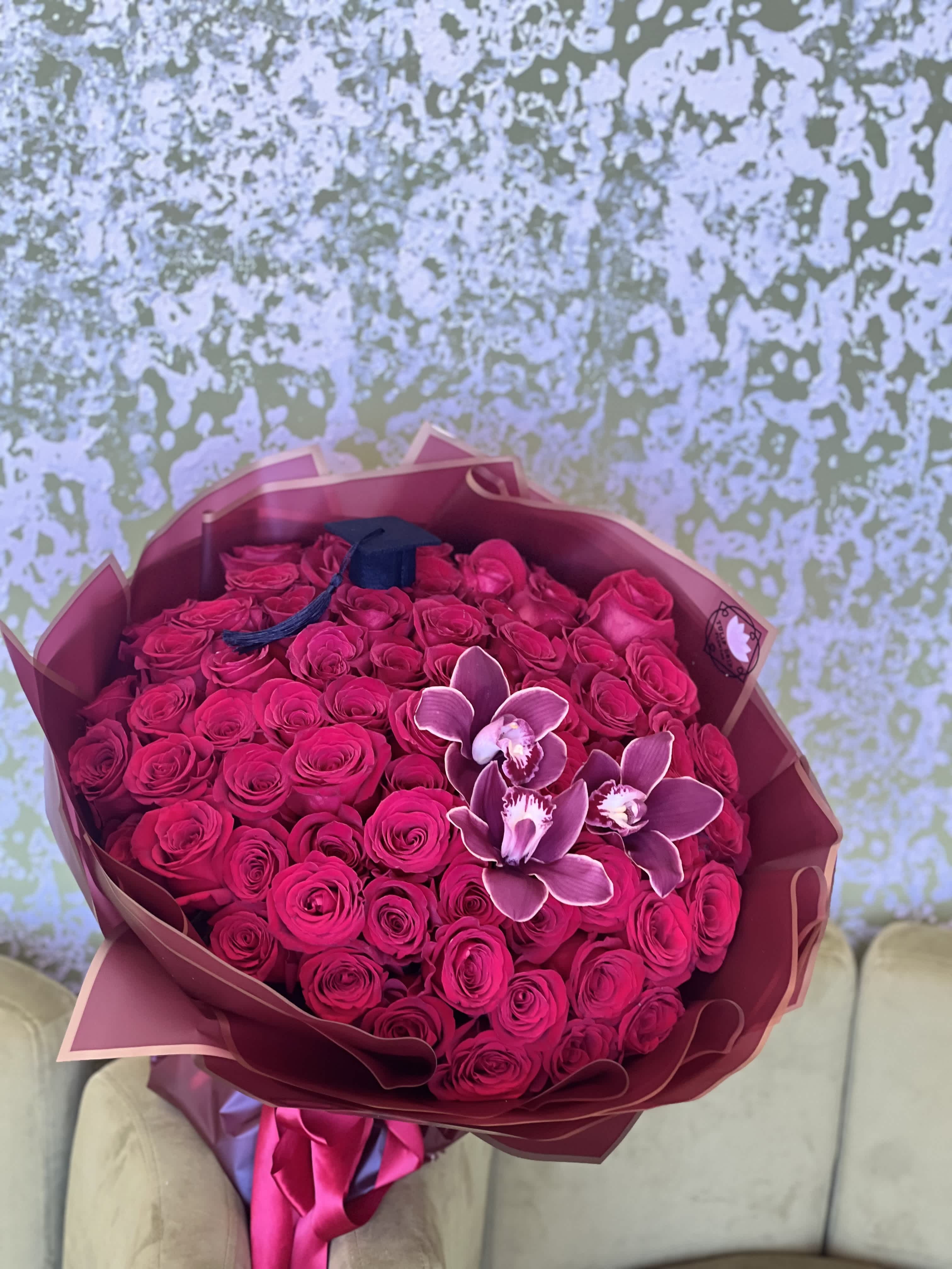 Large bouquet of hot pink roses with a few orchid blooms