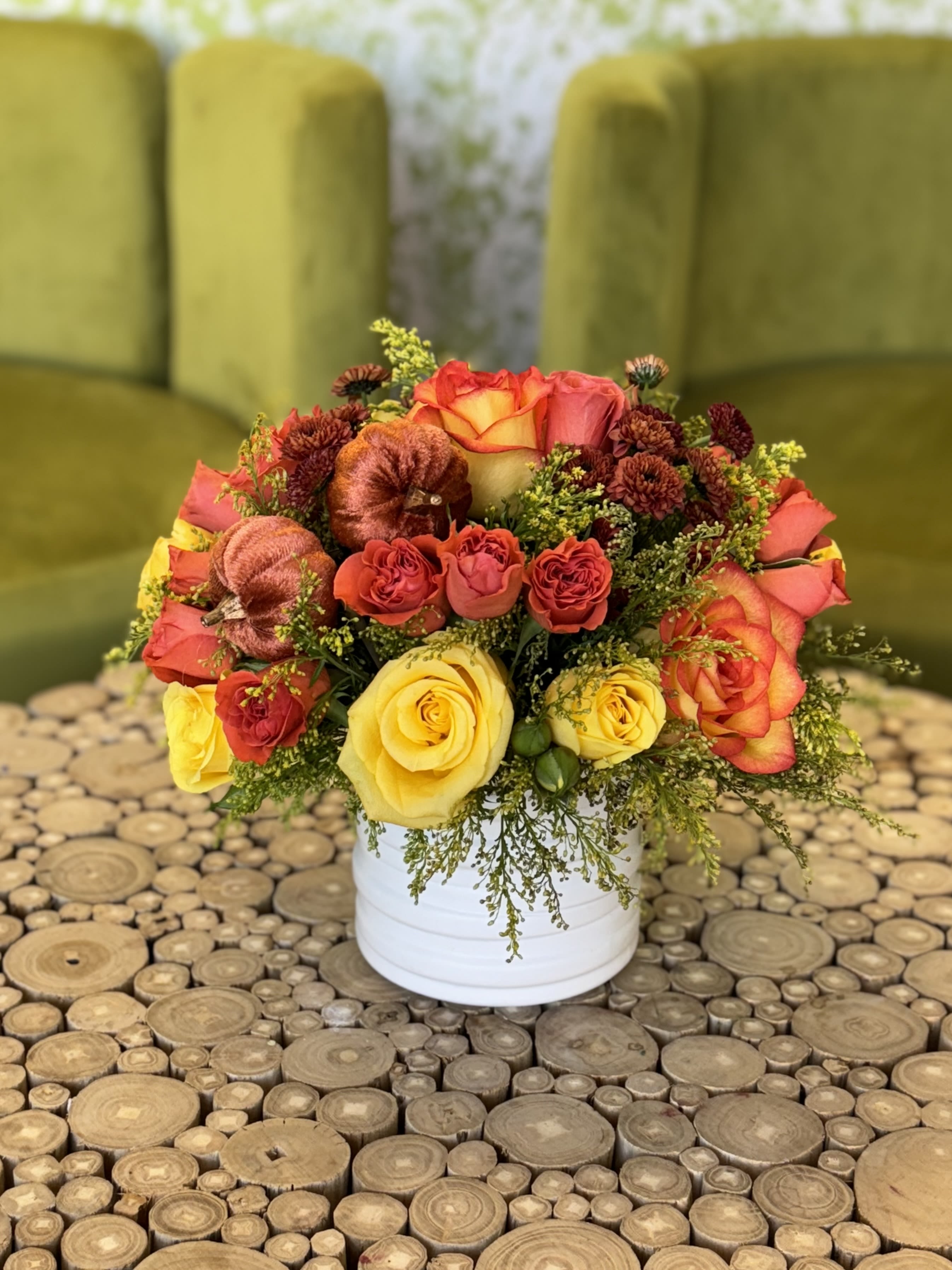 Bouquet of yellow and orange roses in a white container