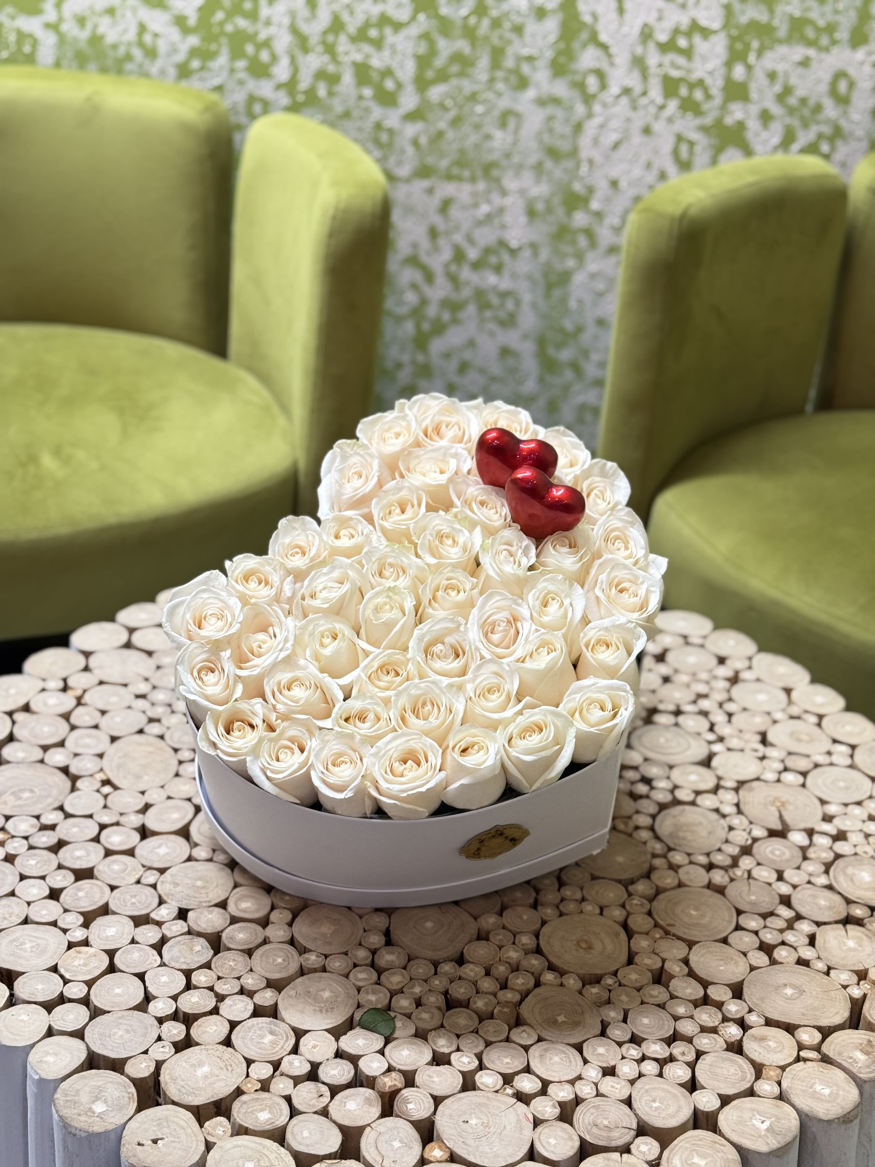 Heart-shaped box of white roses with red heart accents