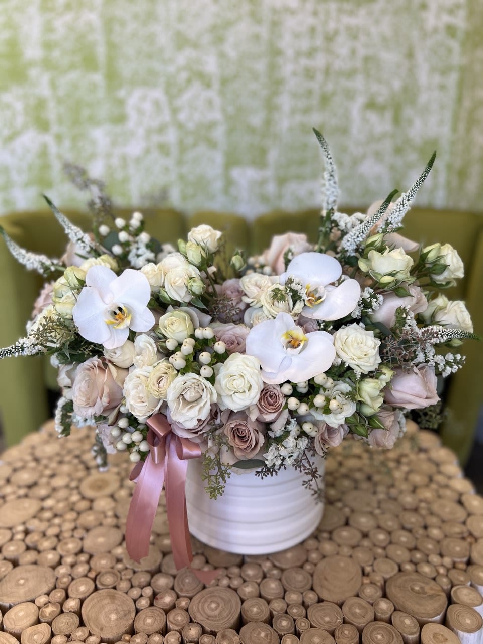 Pastel bouquet of roses and white orchids in a white vase