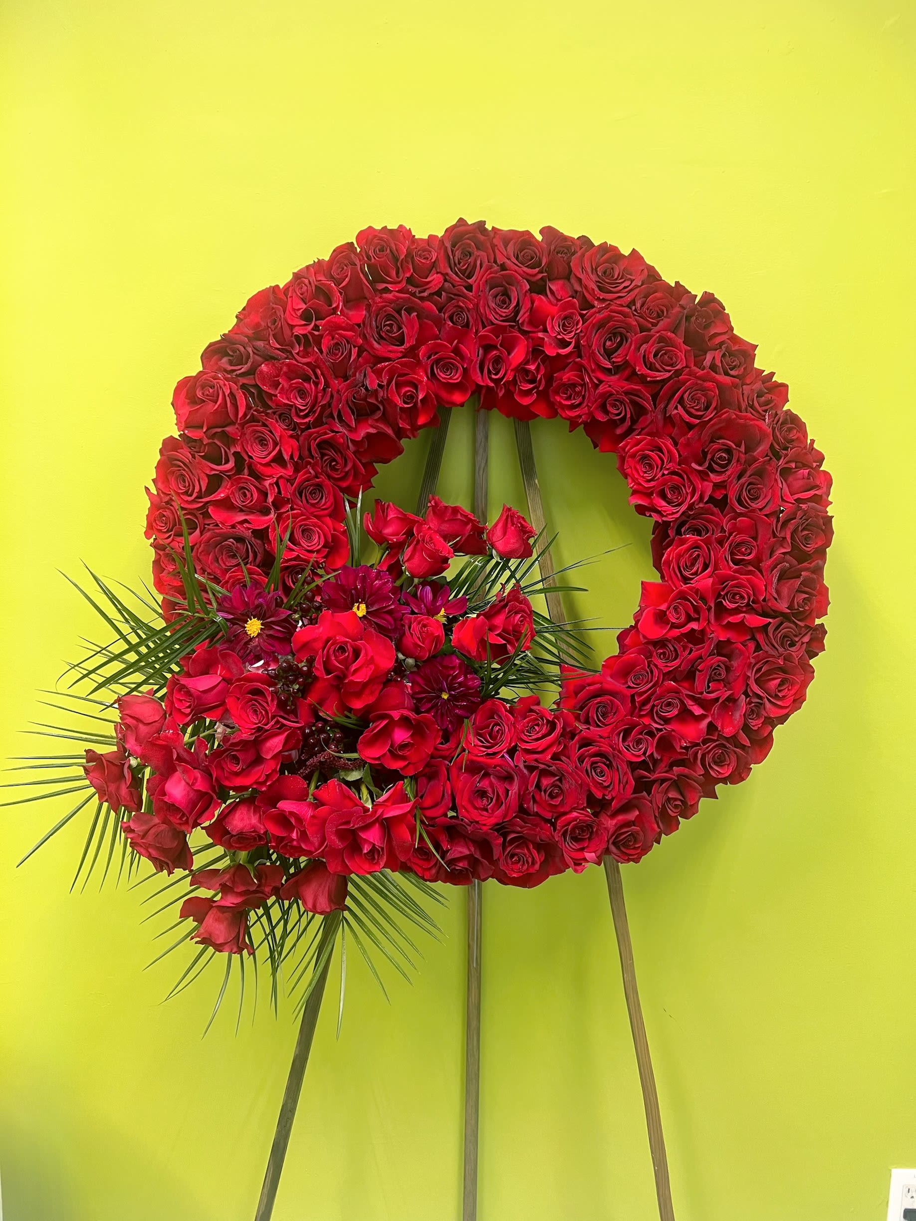 Large red rose wreath with a floral cluster at the lower left