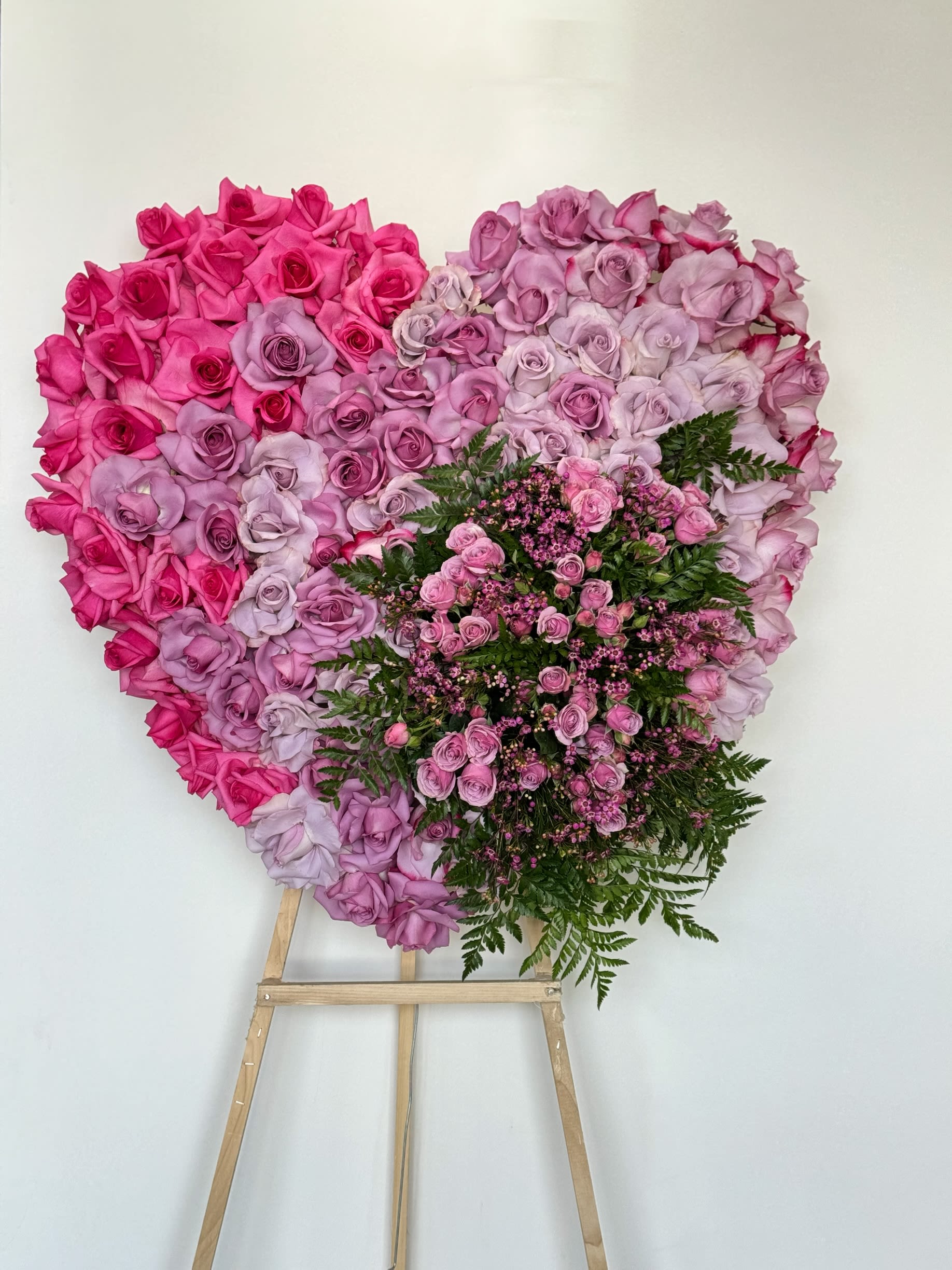 Heart-shaped pink and lavender rose arrangement on an easel