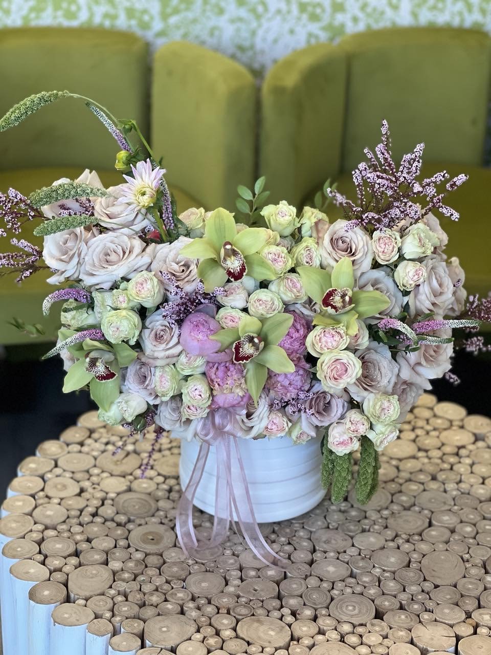Large pastel flower arrangement in a white container