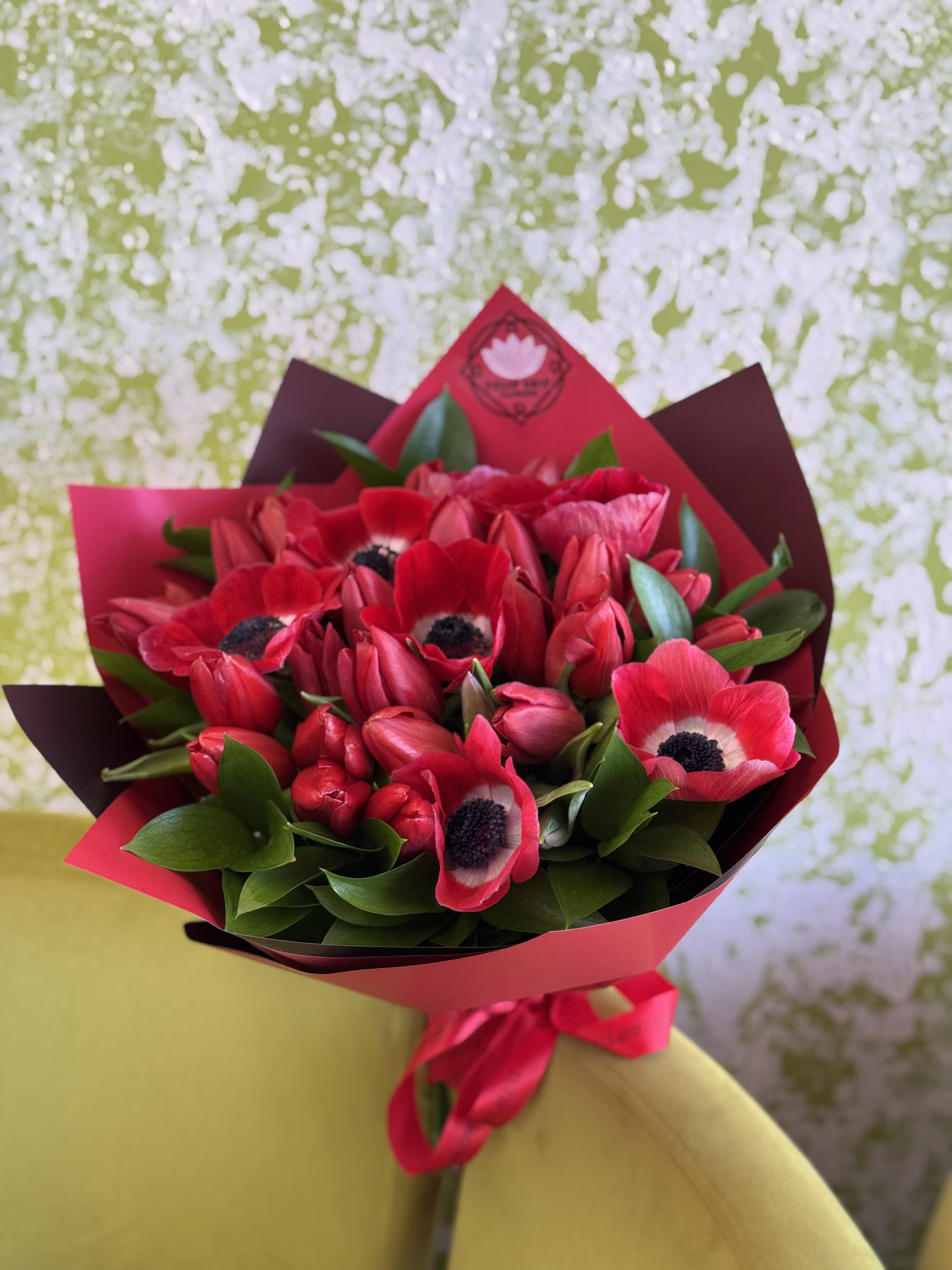 Bouquet of red anemones wrapped in pink and burgundy paper
