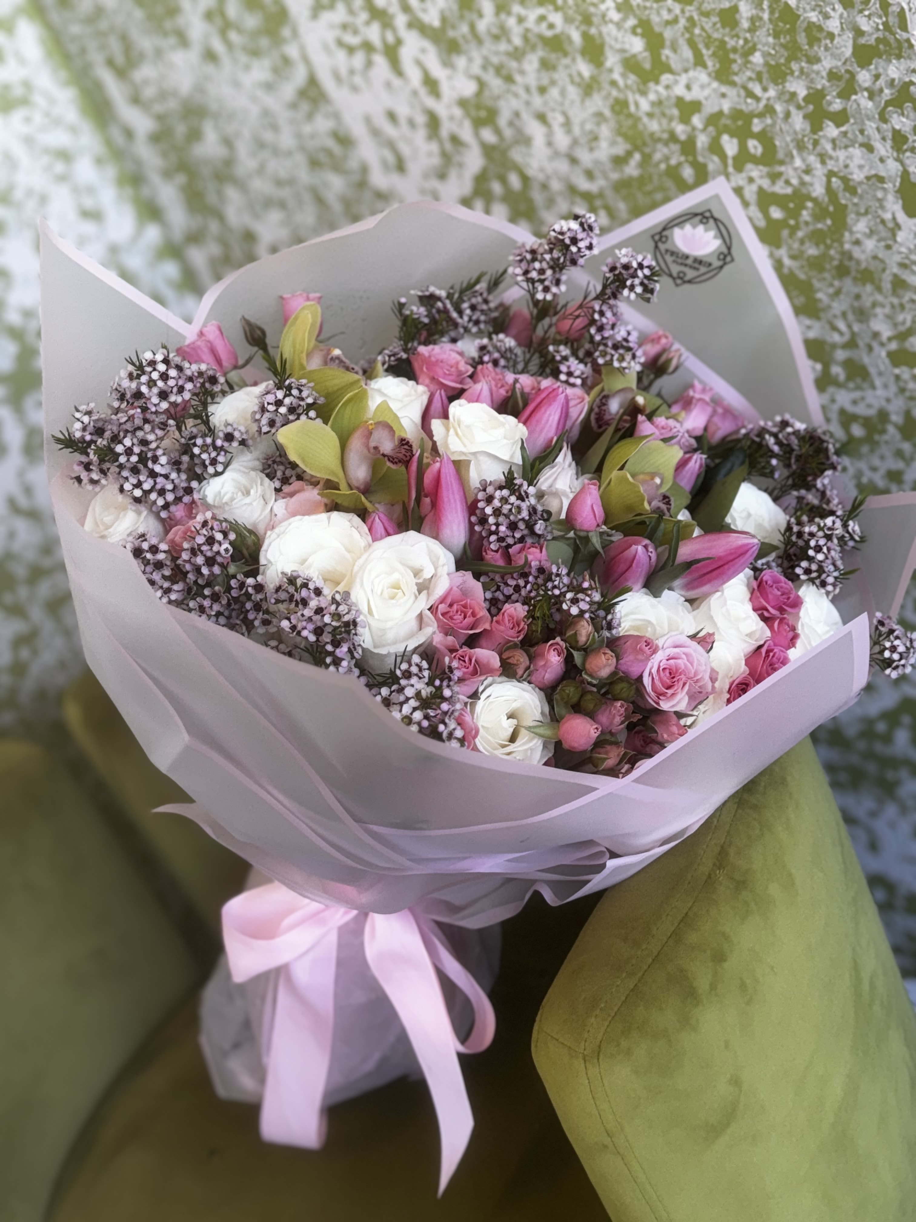 Pink and white bouquet with roses and lilies wrapped in pale paper