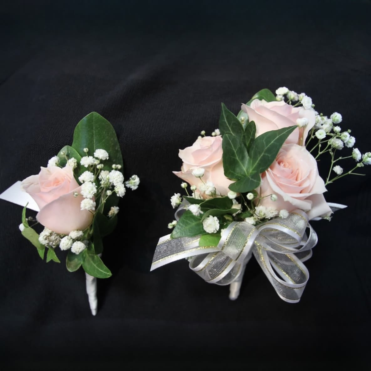 Blush Elegance Rose Set - Blush Elegance Rose Corsage and Boutonniere Set – a timeless pairing of soft blush roses, baby’s breath, and lush greenery. Perfect for weddings, proms, quinceañeras, or formal events. This classic floral duo is available as a set or sold individually.
