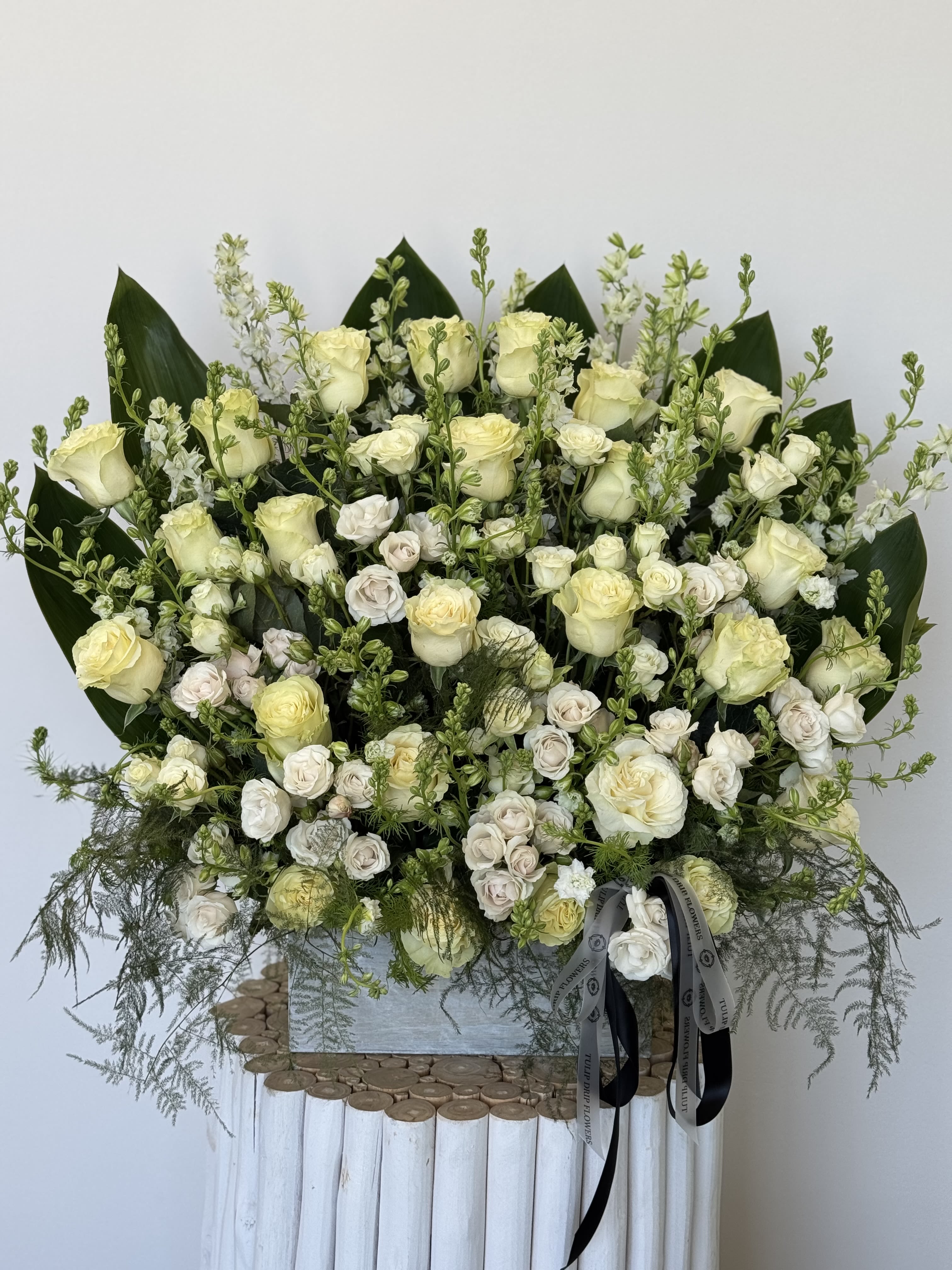 Large bouquet of cream roses and white spray roses with greenery