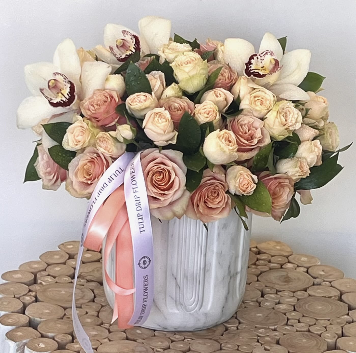 Bouquet of blush roses and white orchids in a white vase