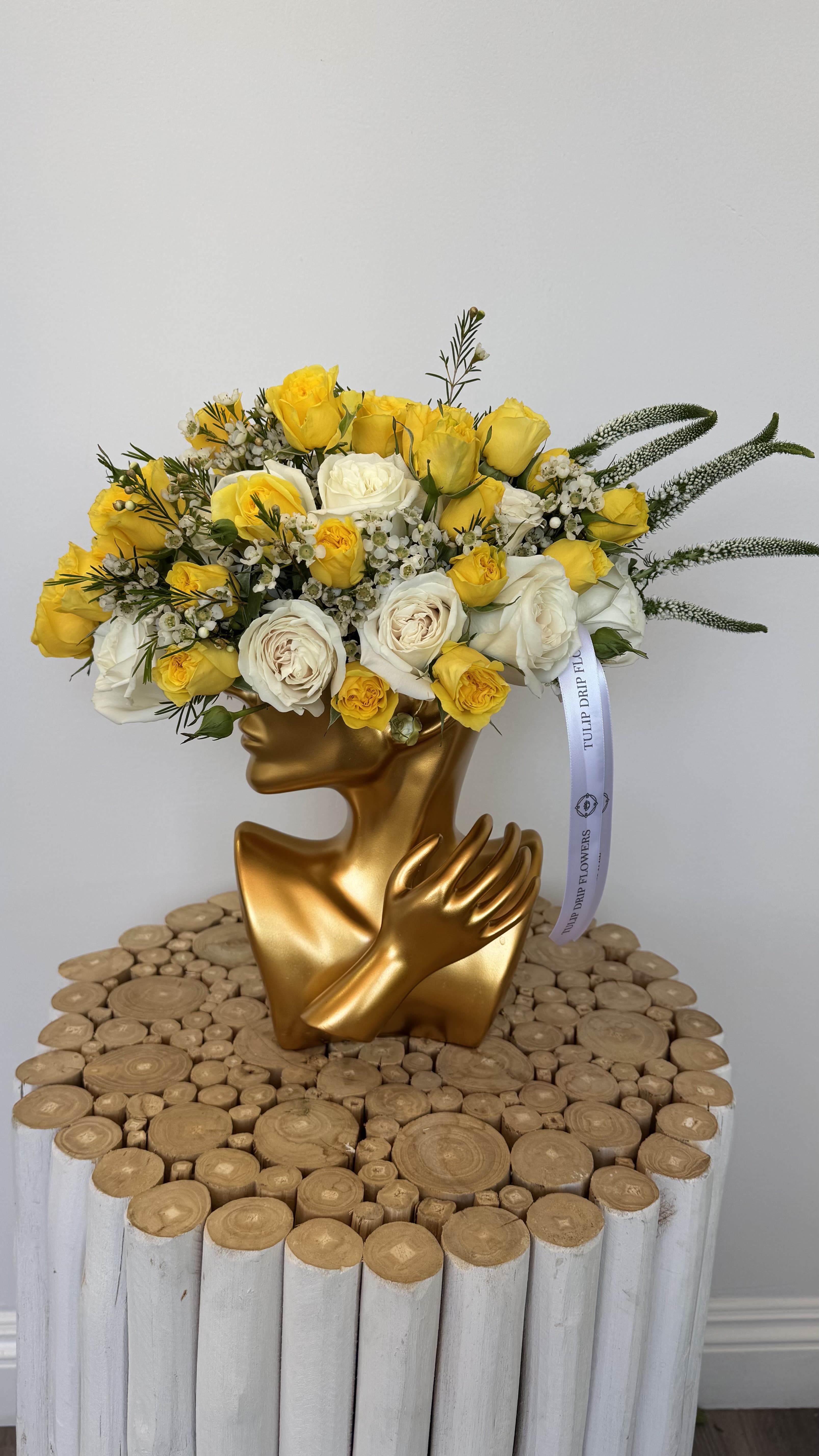 Yellow and white rose bouquet in a gold sculptural vase