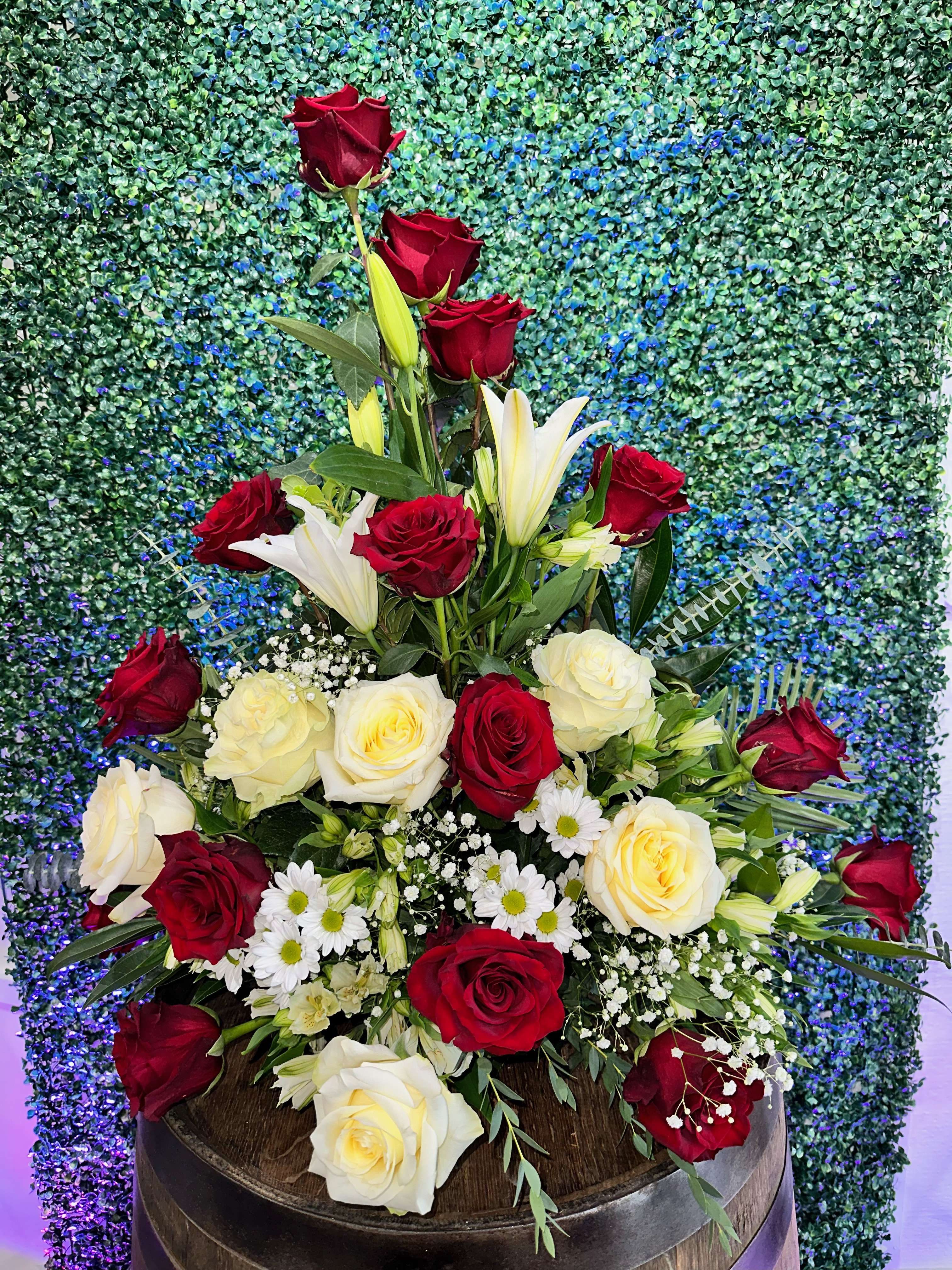 Tall bouquet of red and white roses with lilies and daisies