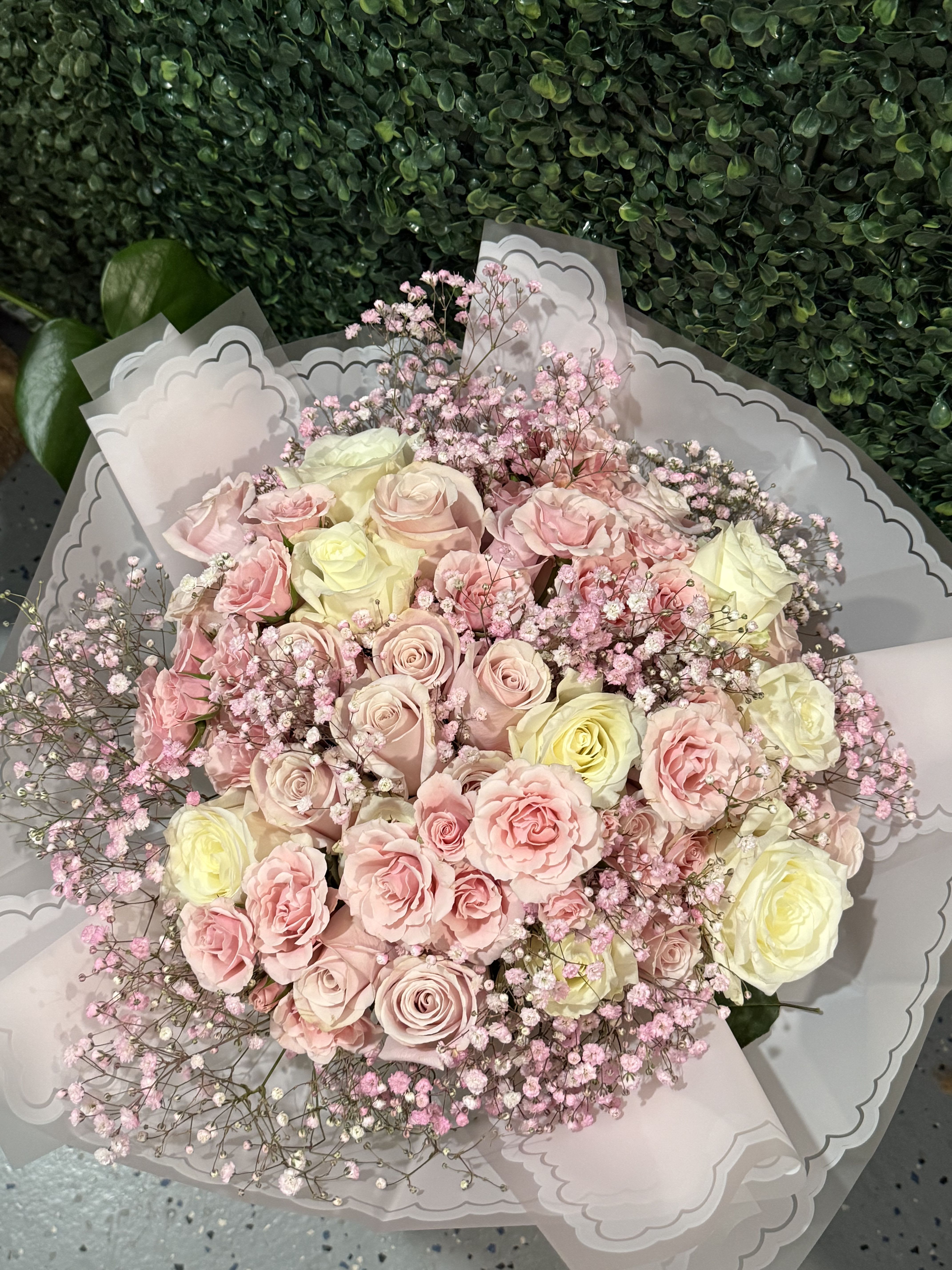 Angel Kisses Bouquet  - A dreamy wrapped bouquet featuring lush roses in pink, and creamy tones, accented with baby’s breath for an extra touch of sweetness. Flower shades, wrap color, and wrap style may vary based on availability.   NO VASE INCLUDED