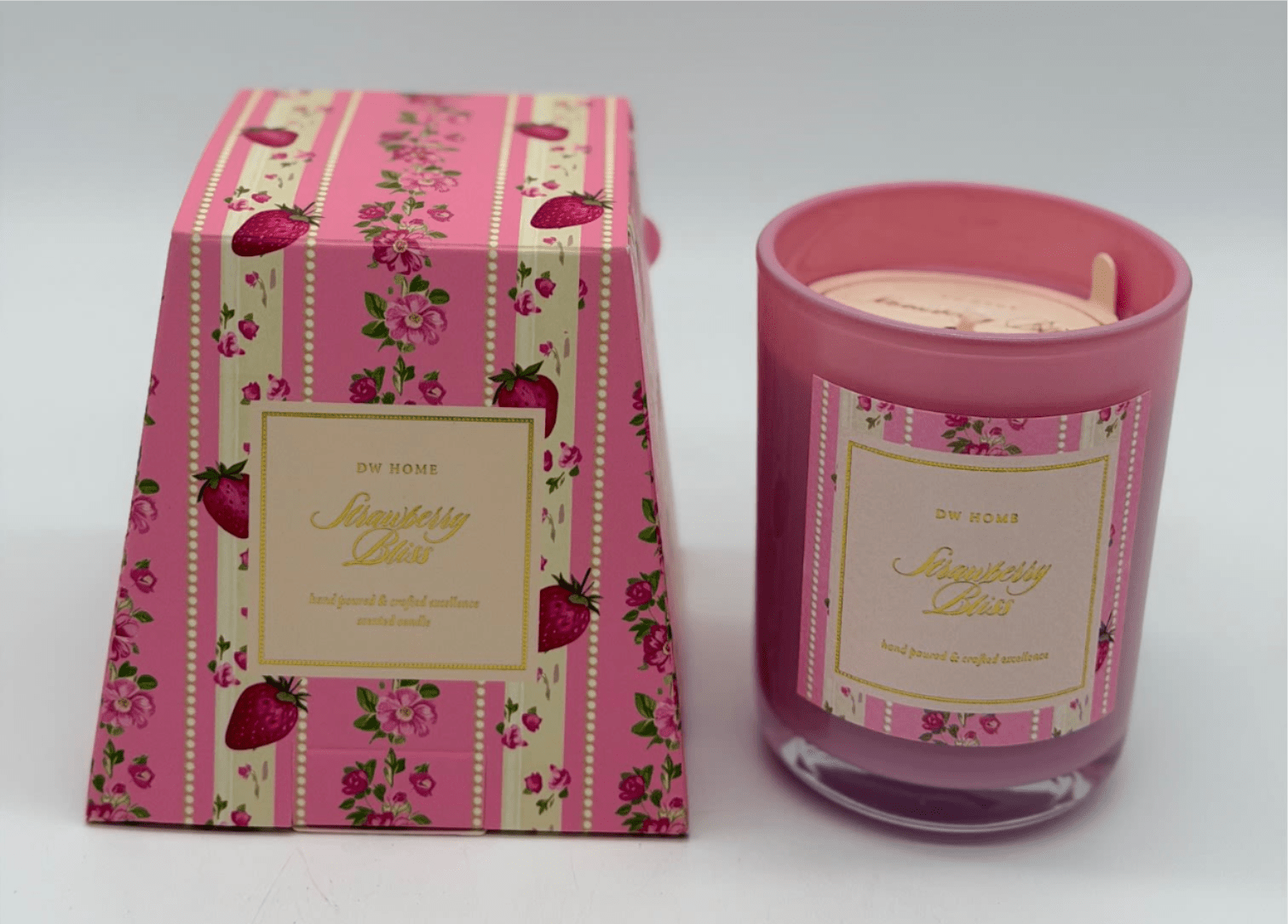 Pink strawberry-scented candle in a glass jar beside matching box