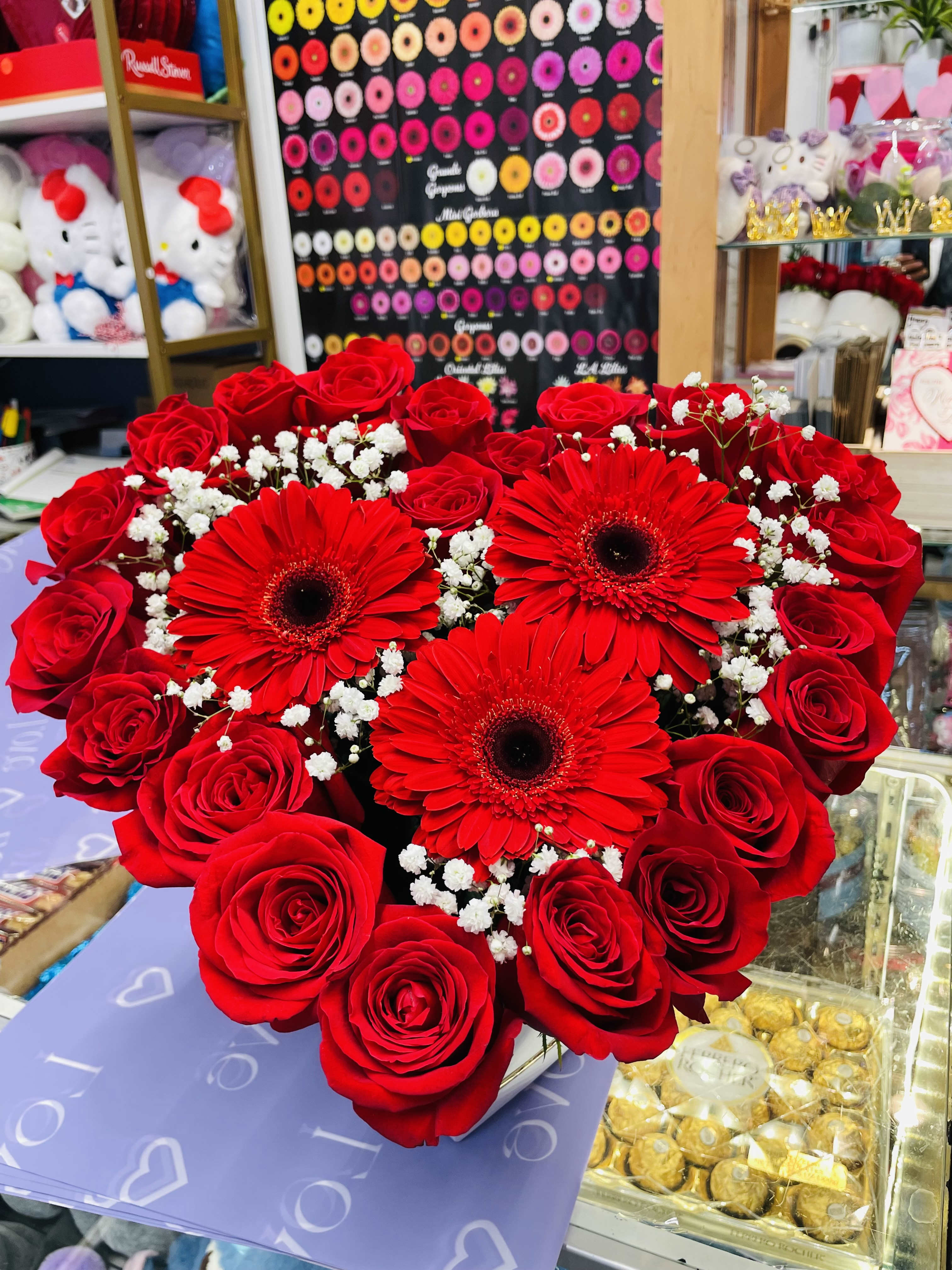 Heart-shaped bouquet of red roses and gerbera daisies with baby's breath