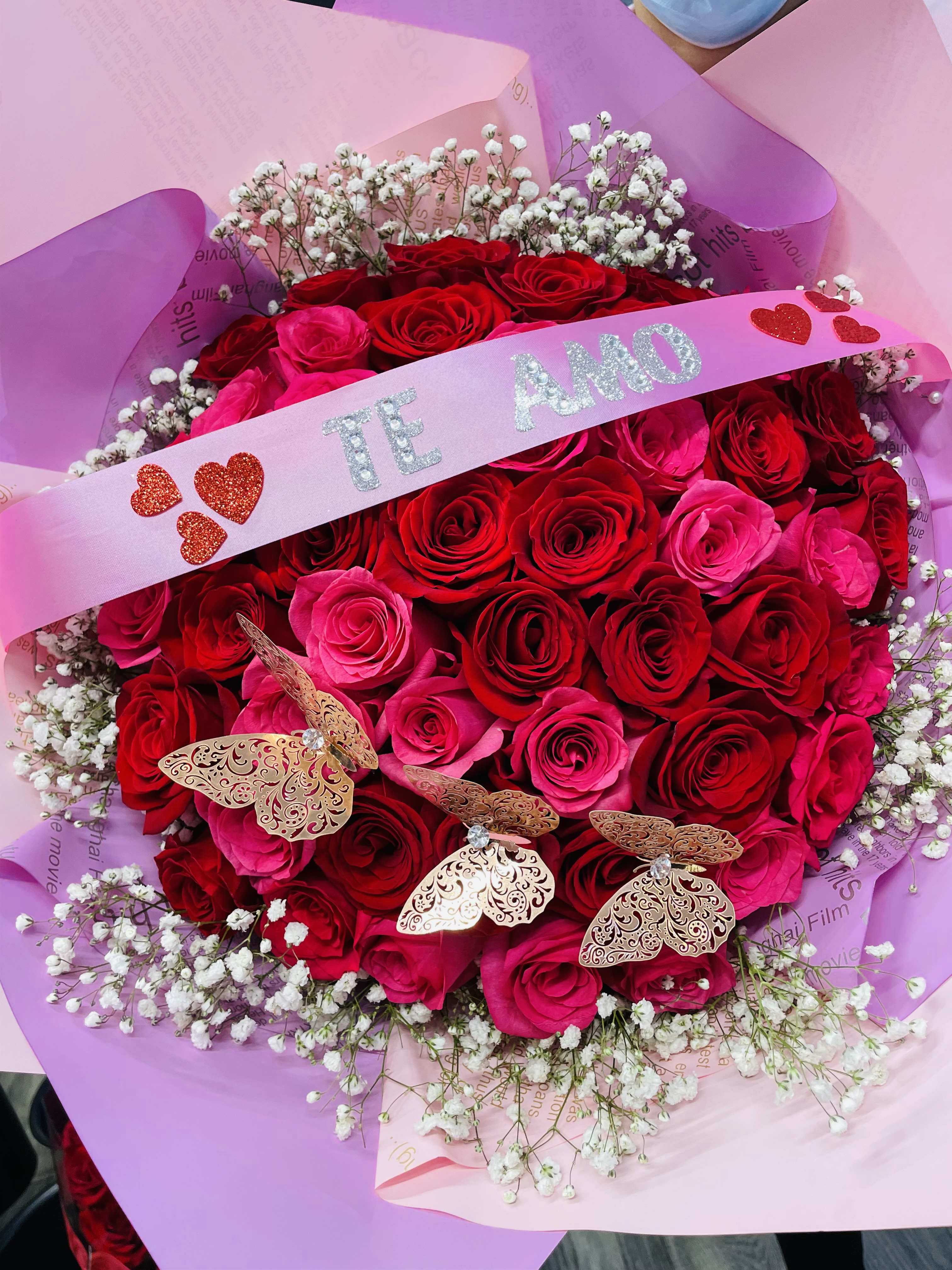 Bouquet of red and pink roses with baby's breath and a pink ribbon