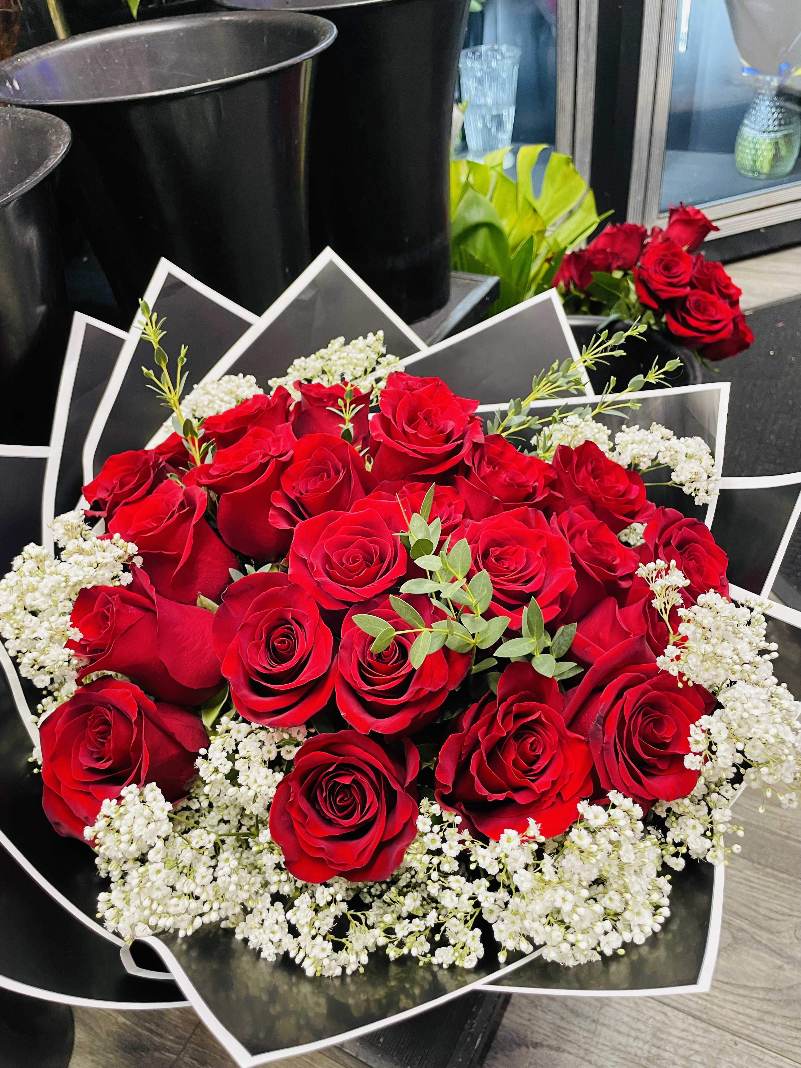 Bouquet of red roses with white baby's breath in black wrapping