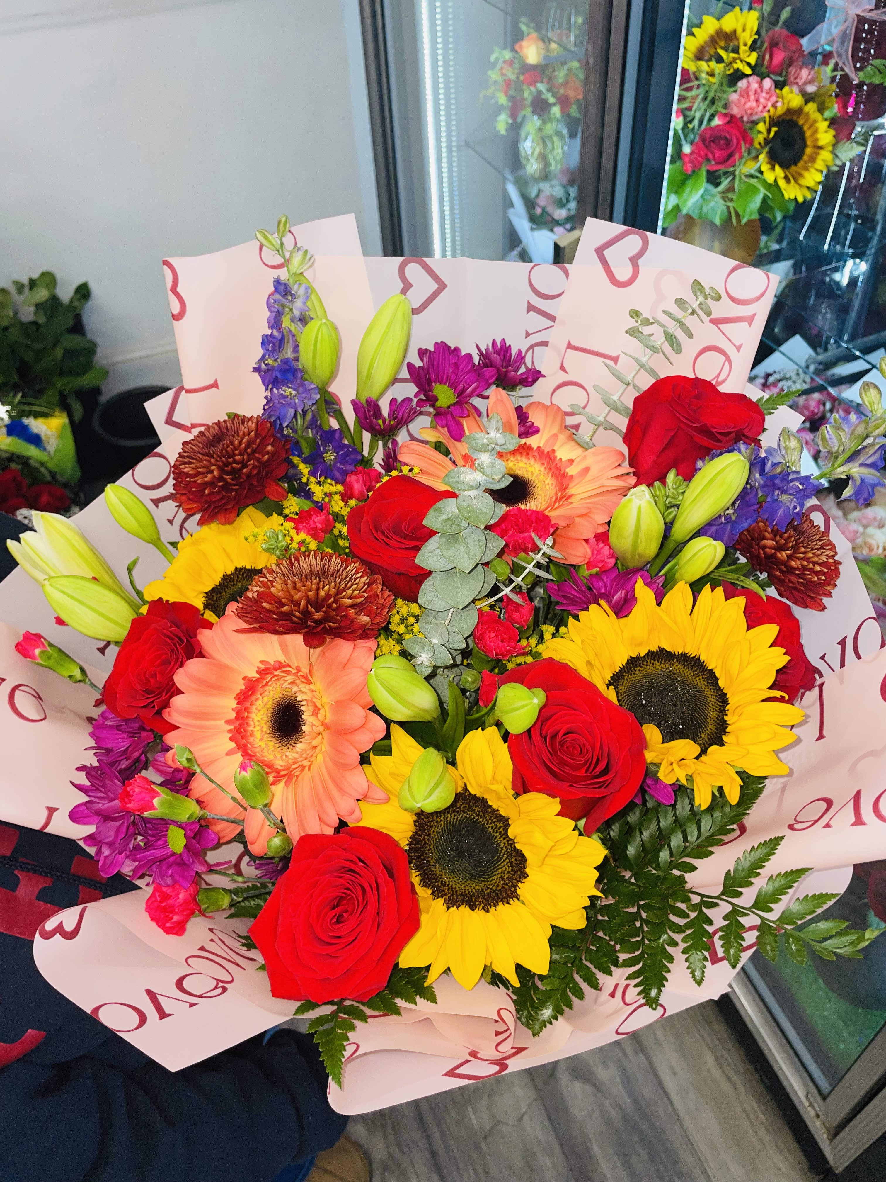 Mixed bouquet of red roses, sunflowers, and pink gerbera daisies