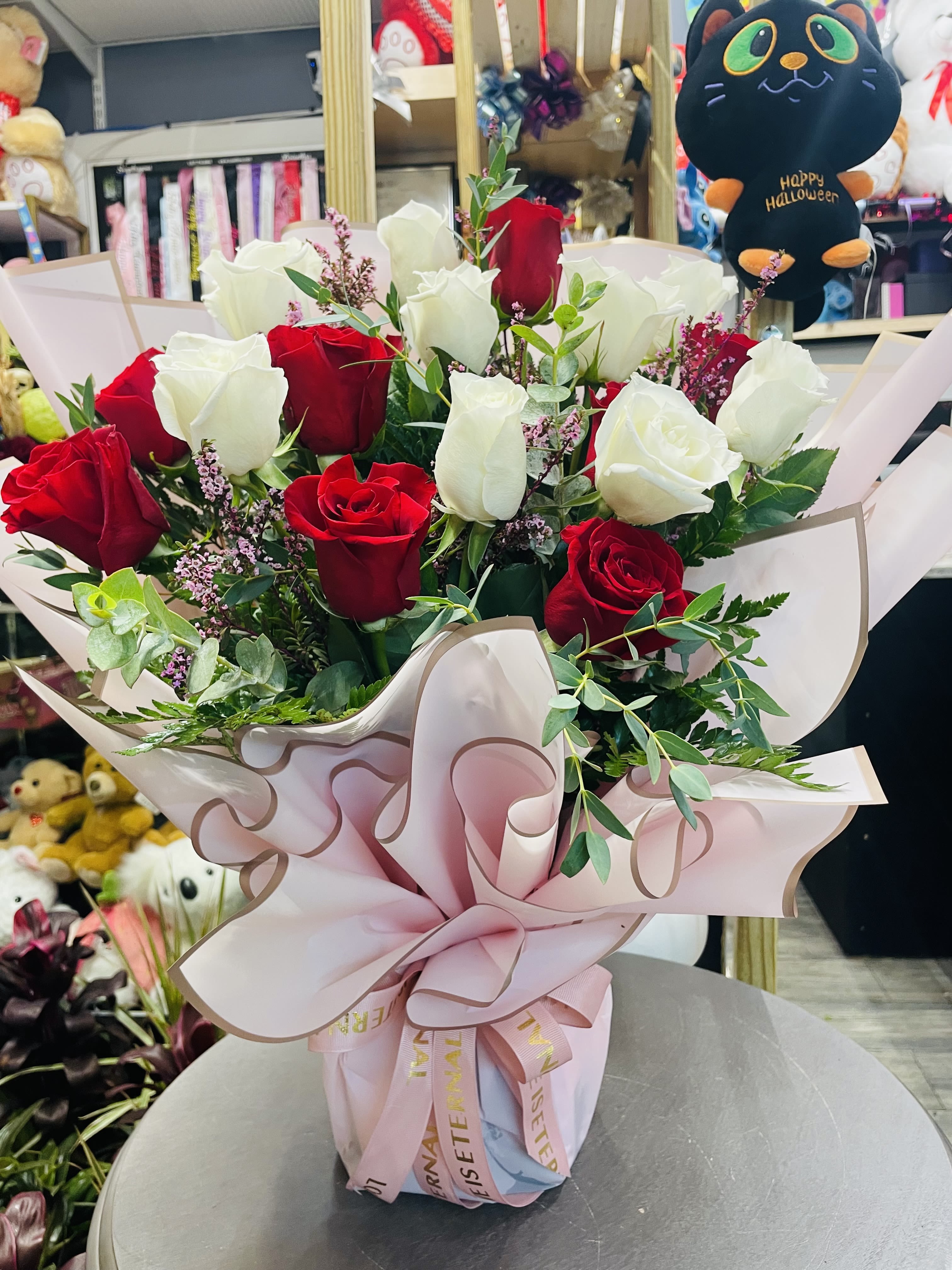 Bouquet of red and white roses wrapped in pink paper