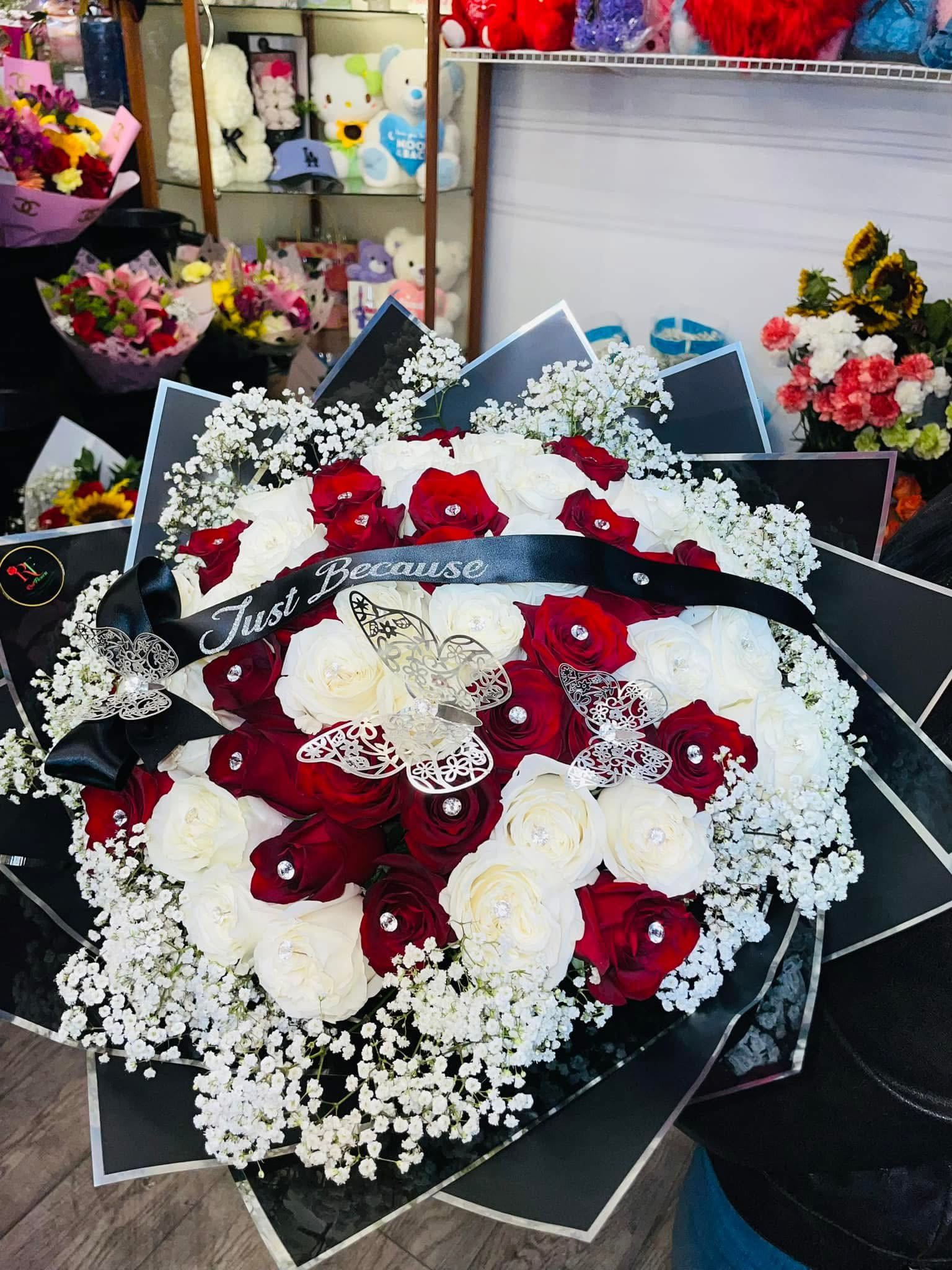 Red and white rose bouquet with baby's breath and a black ribbon
