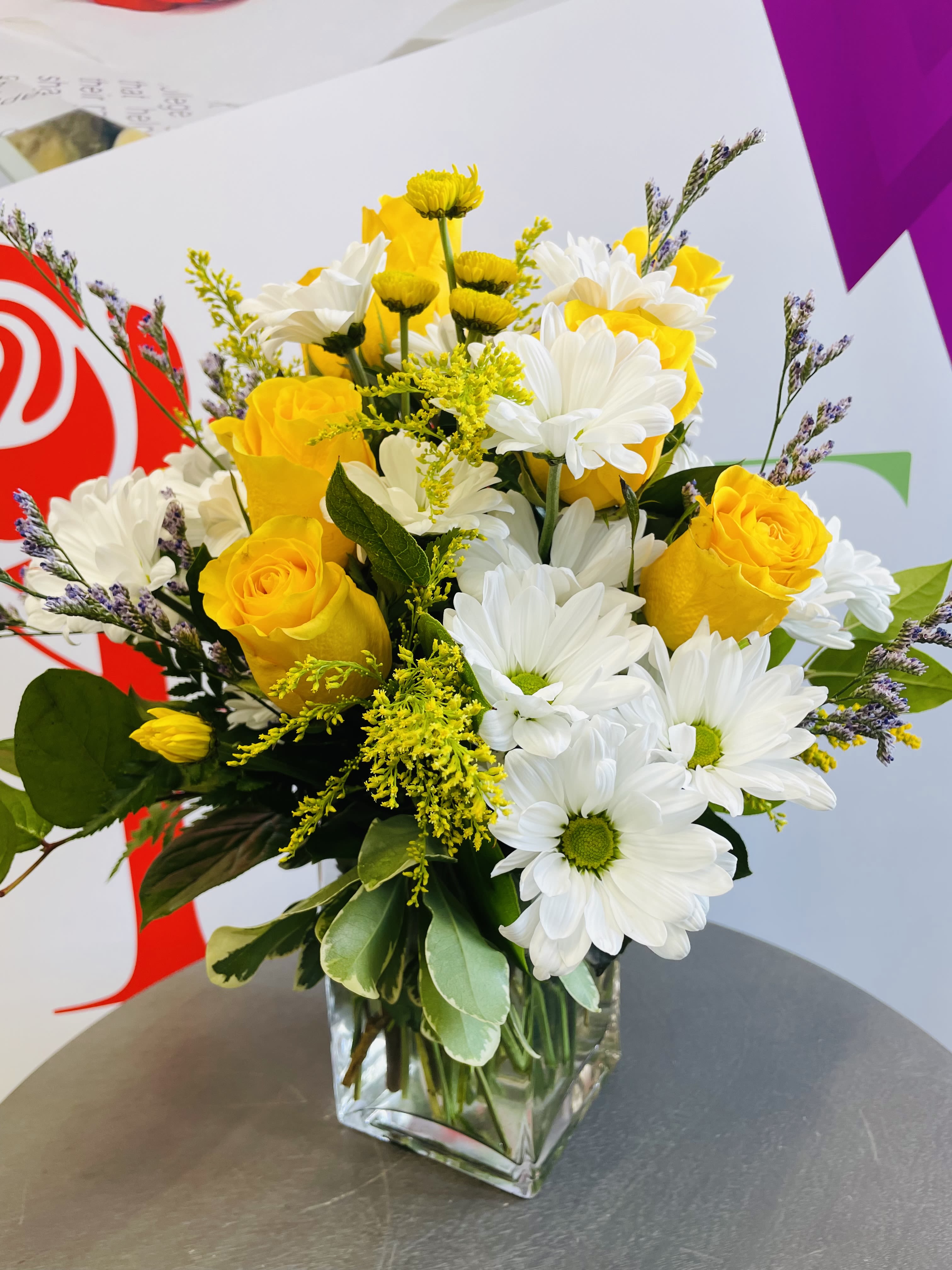 Daisy Me Rollin'  - This arrangement contains spray daisies and spray roses. This is a great birthday gift. 