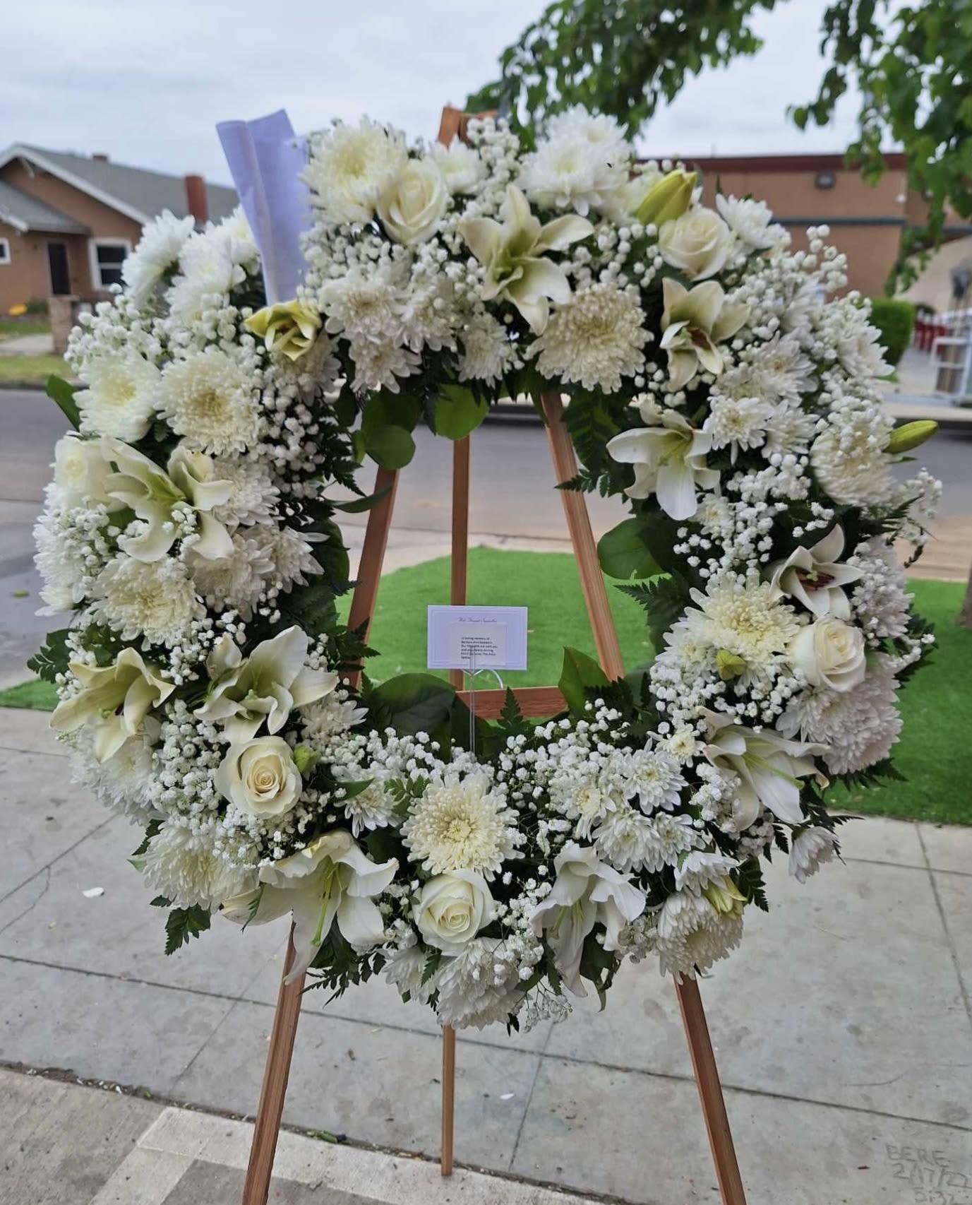Large white floral wreath on a wooden easel