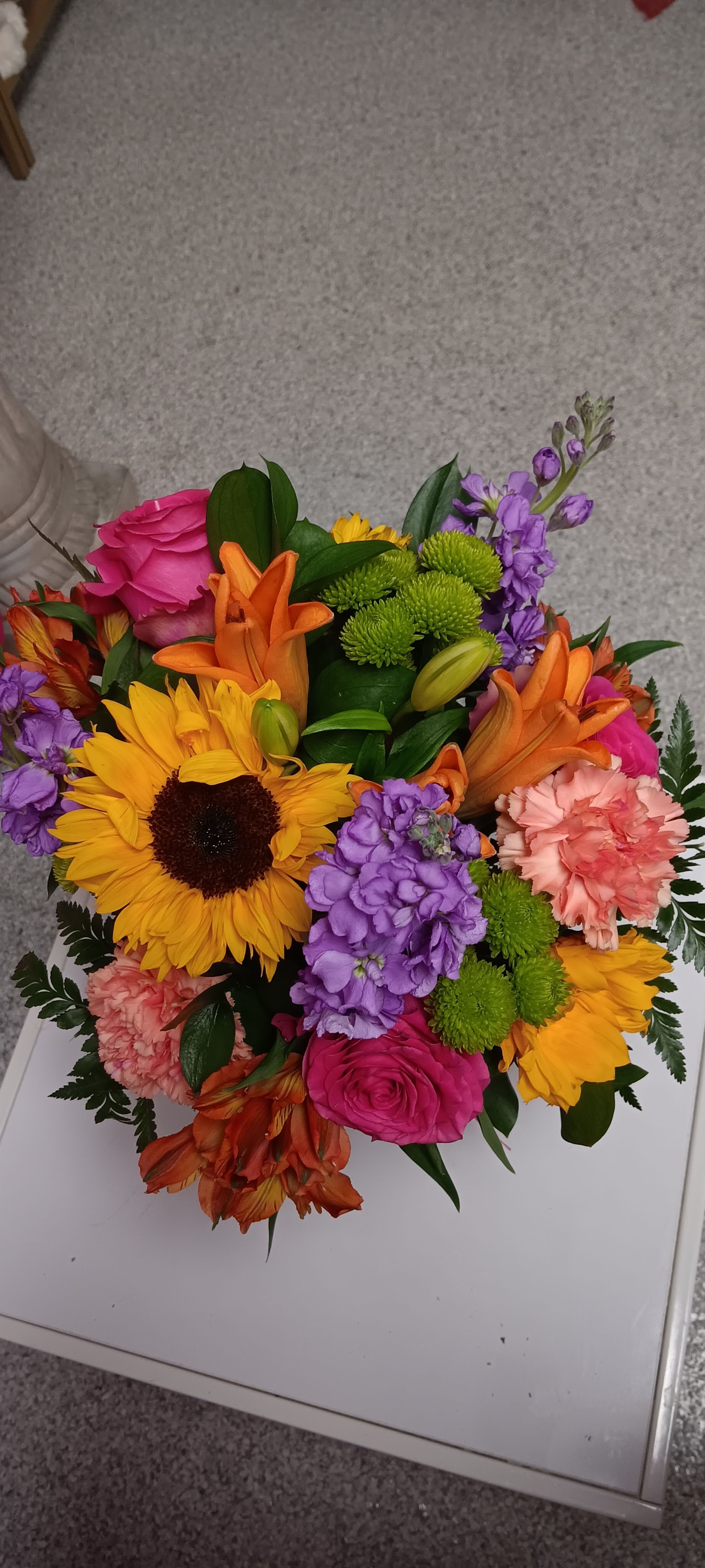Colorful mixed bouquet with sunflowers, roses, lilies, and purple blooms