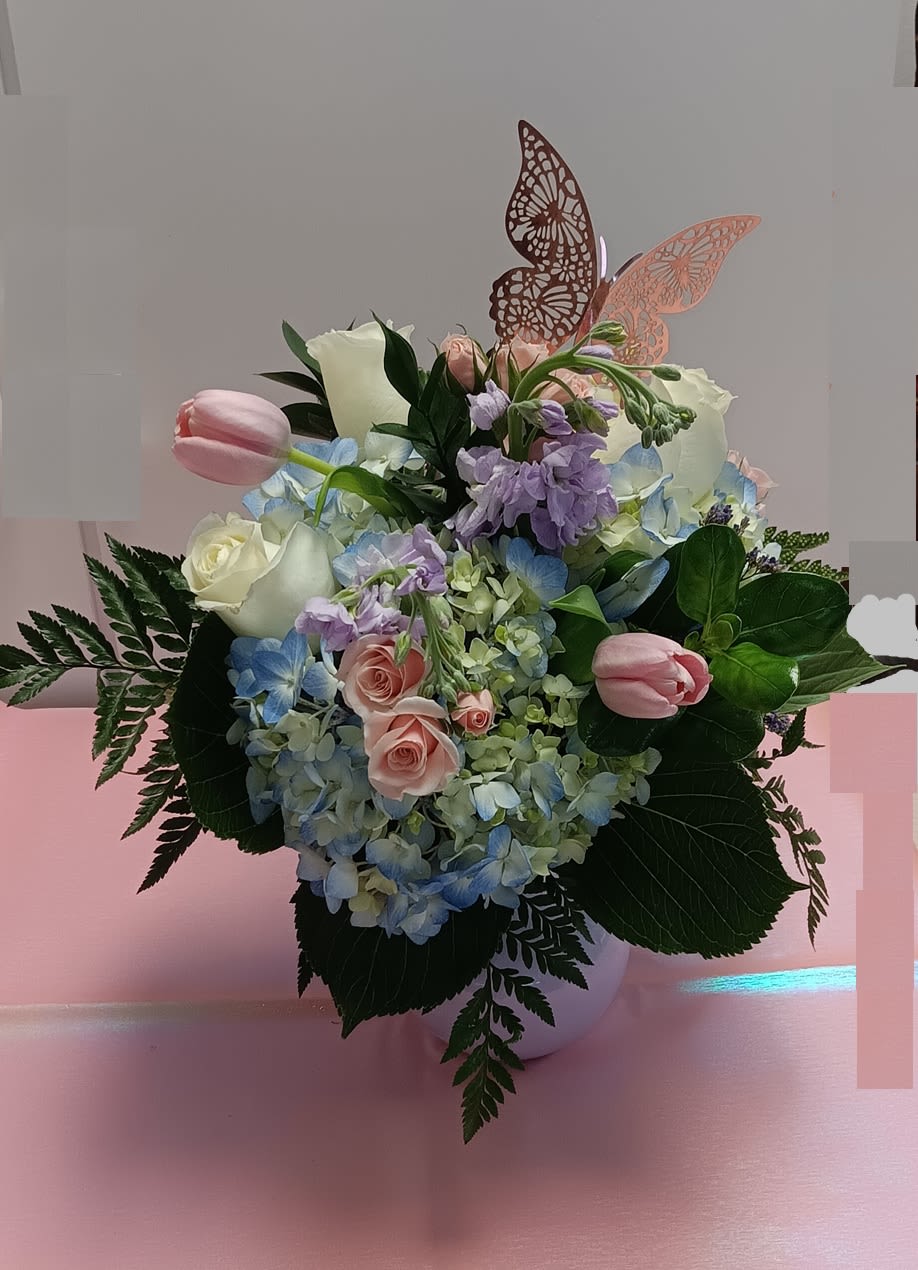 Pastel flower arrangement with roses, hydrangeas, and tulips in a vase