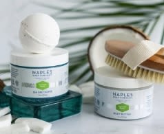 Two hair care jars with a brush and comb on a white surface