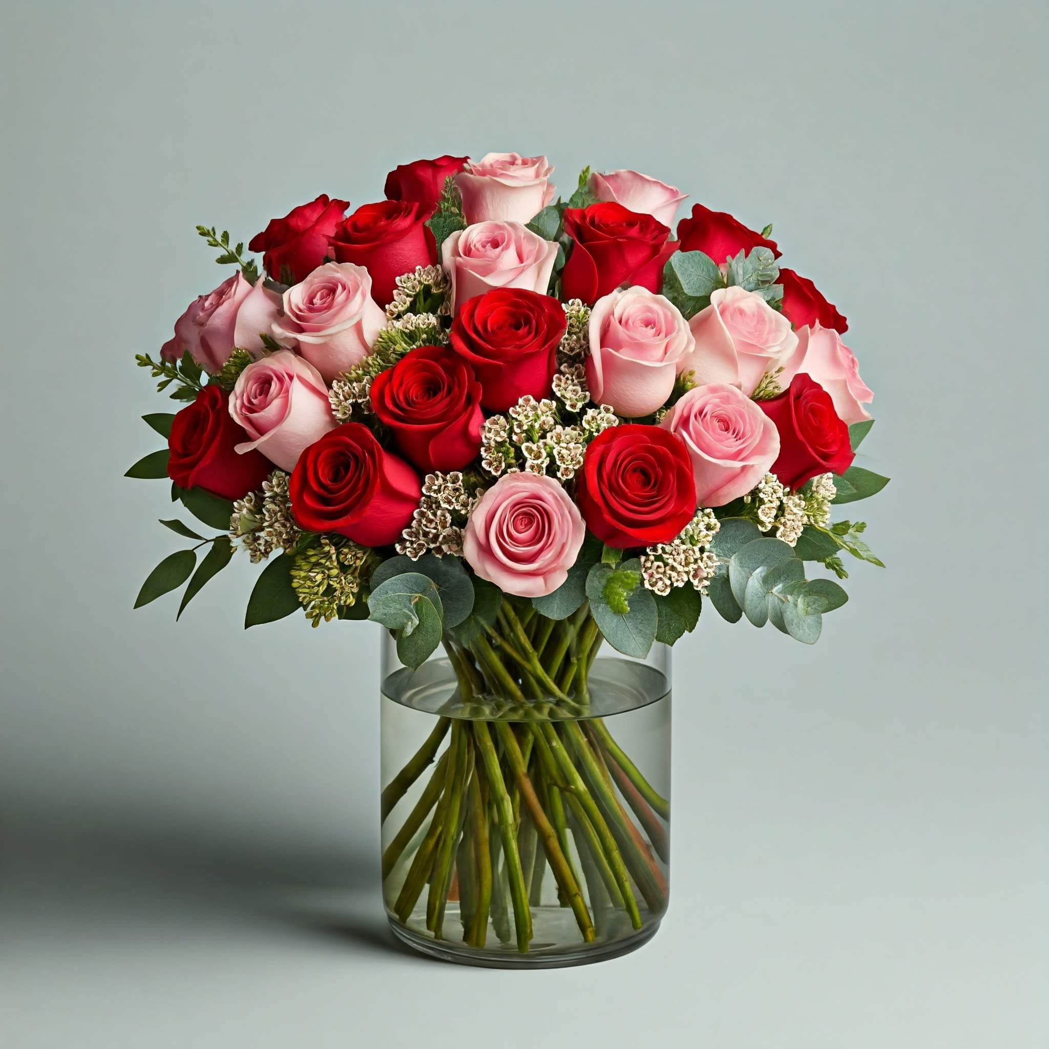 Bouquet of red and pink roses in a clear glass vase