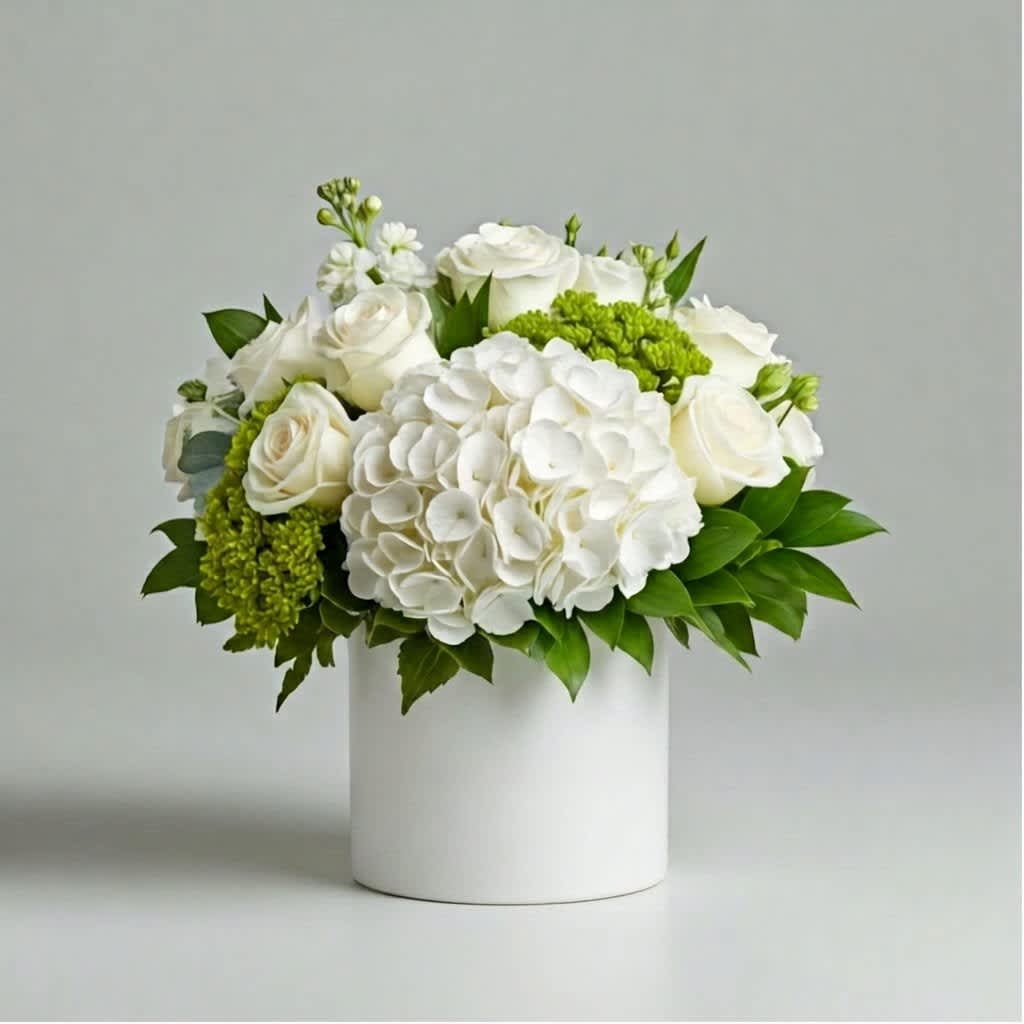 White roses and hydrangeas in a white cylindrical vase