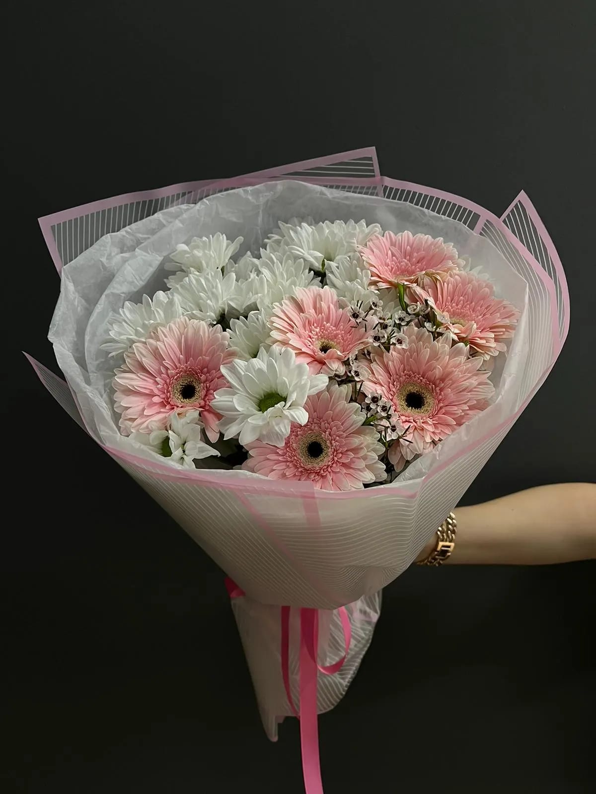 Bouquet of pink and white gerbera daisies wrapped in pink paper