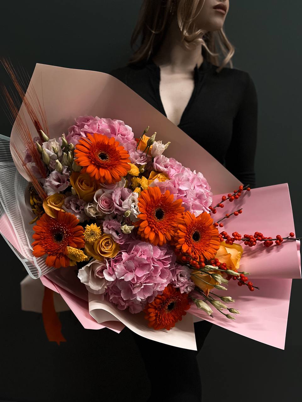 Large bouquet of orange gerbera daisies and pink hydrangeas wrapped in pink paper