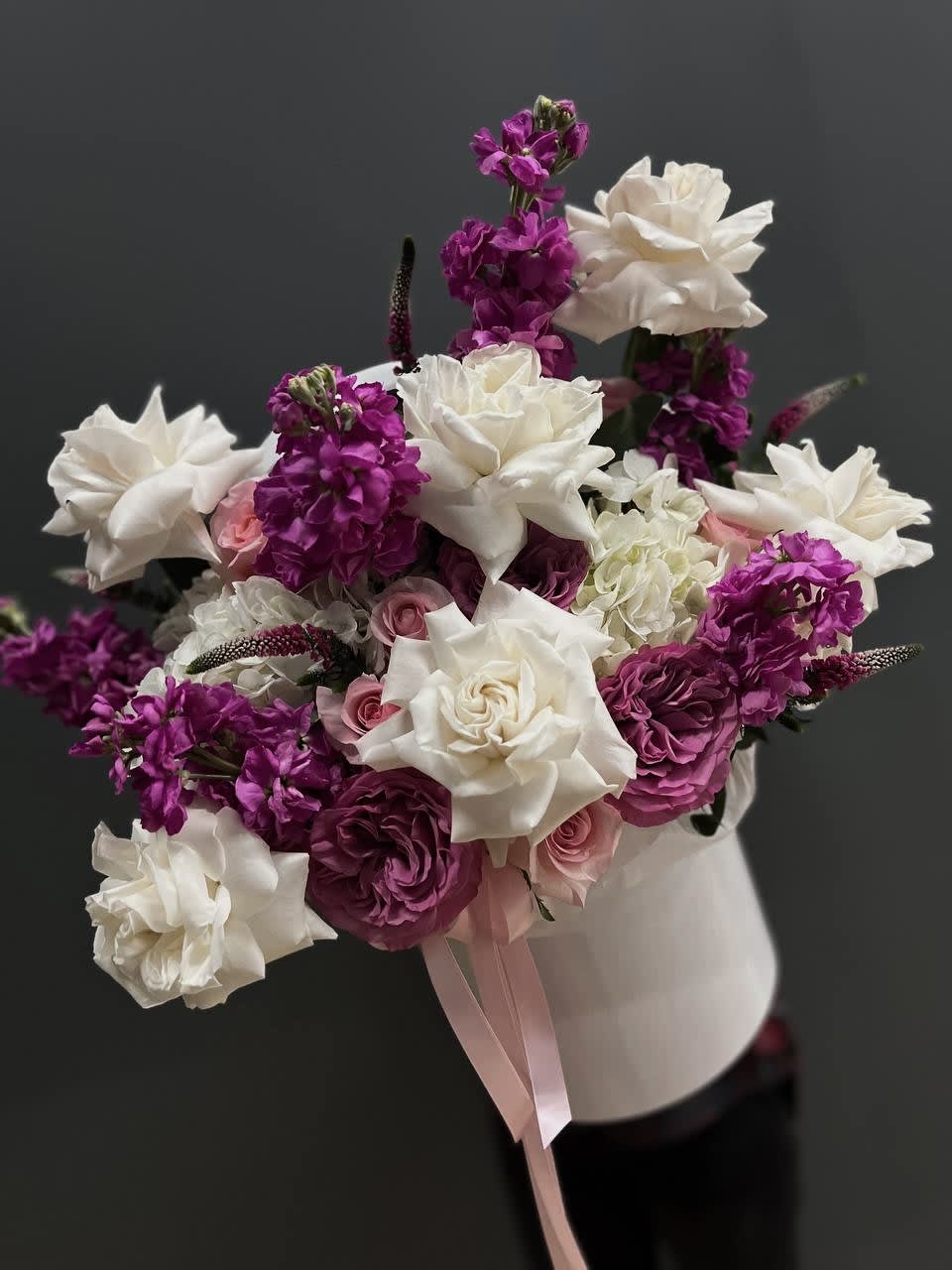 Bouquet of white and magenta flowers with pink roses in a white vase