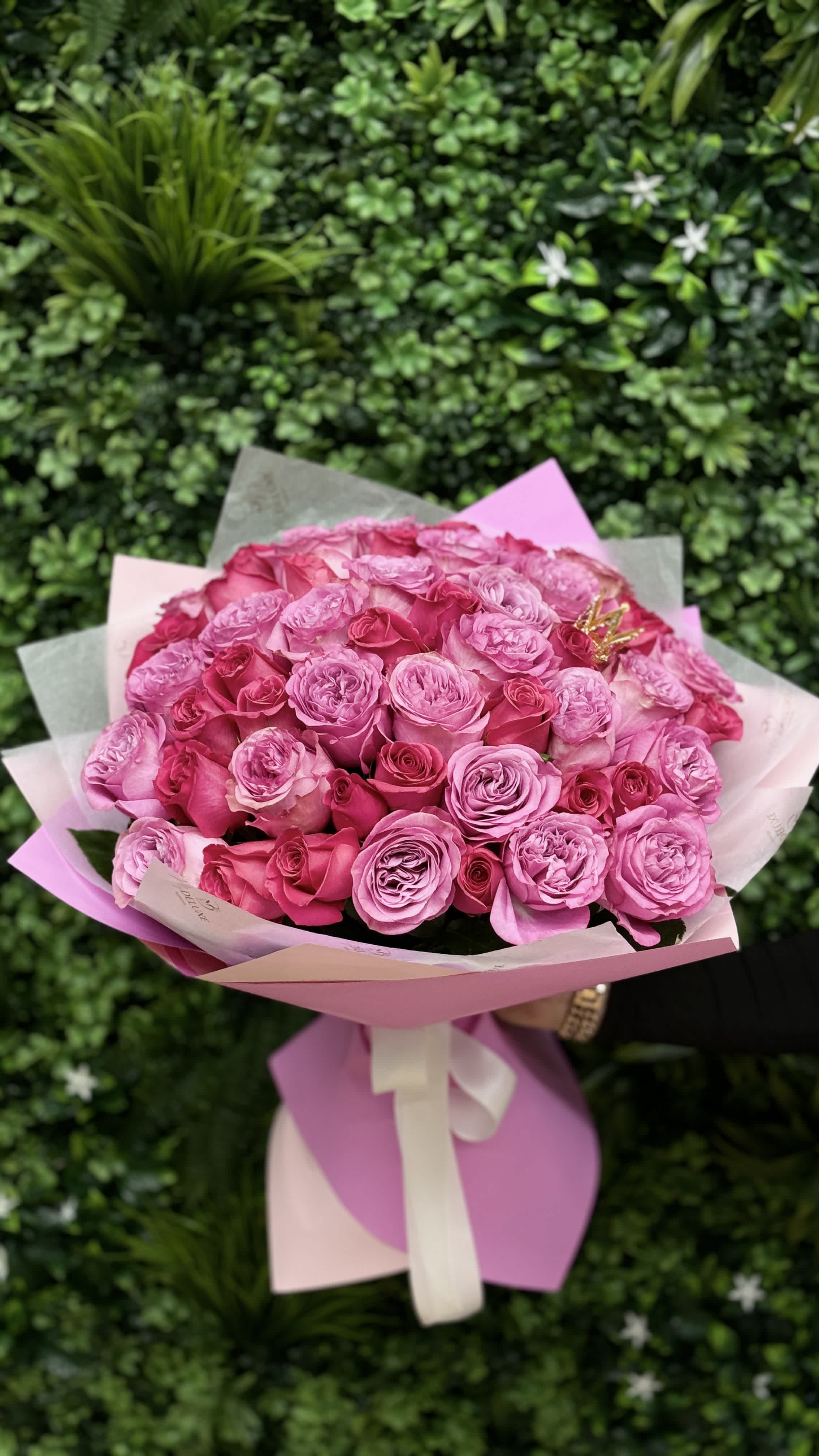 Bouquet of pink roses wrapped in pastel paper with a ribbon